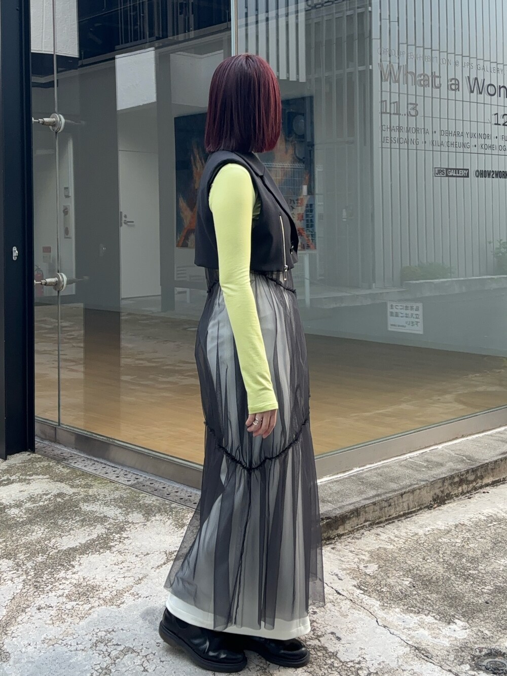 ブラック系のワンピース、グリーン系のTシャツ/カットソー、ホワイト系のスカートを着用したレディースの秋コーディネートの2枚目の写真