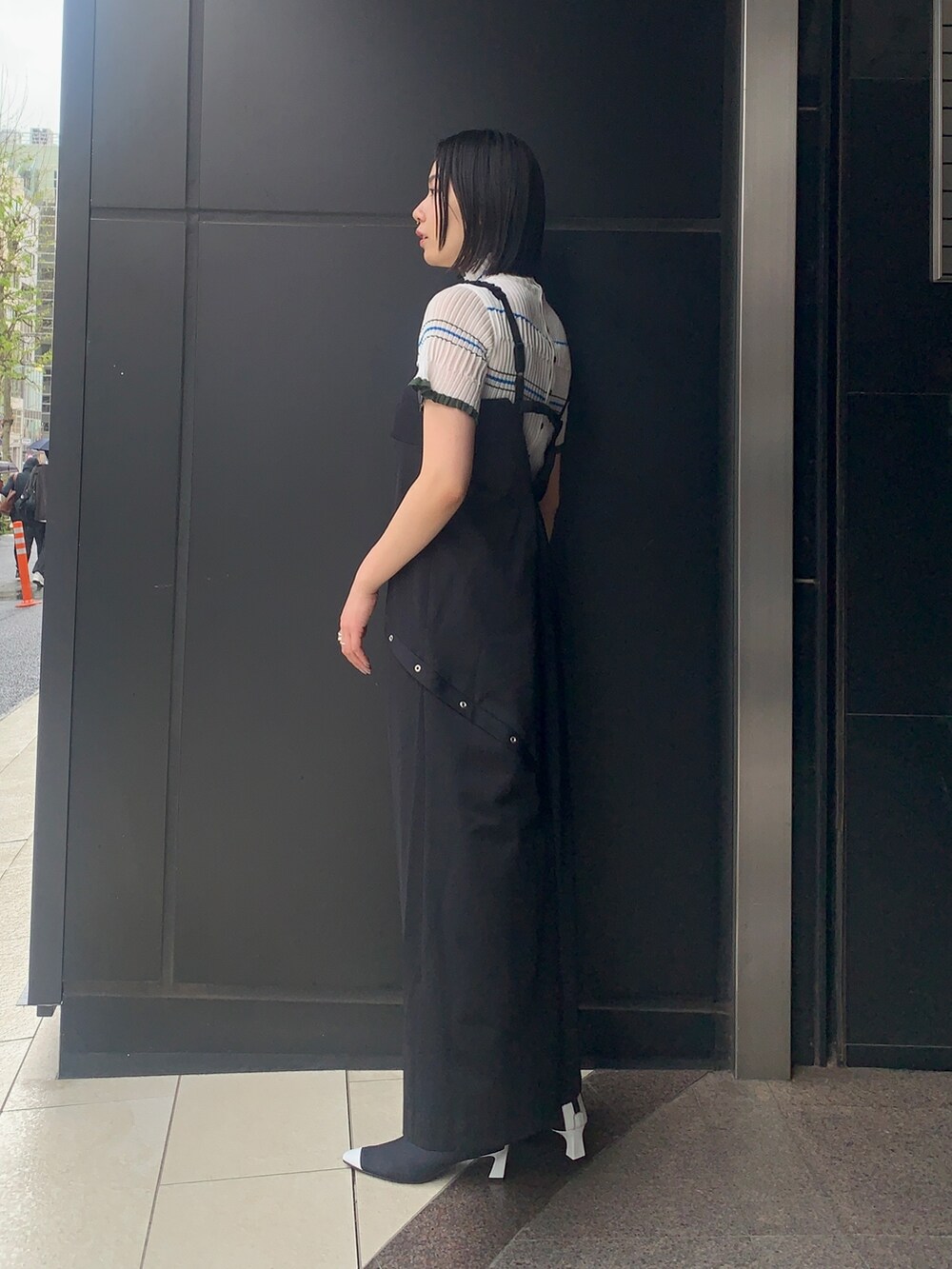 ブラック系のワンピース/ドレス、ベージュ系のニット/セーター、ブラック系のブーツを着用したレディースの春コーディネートの2枚目の写真