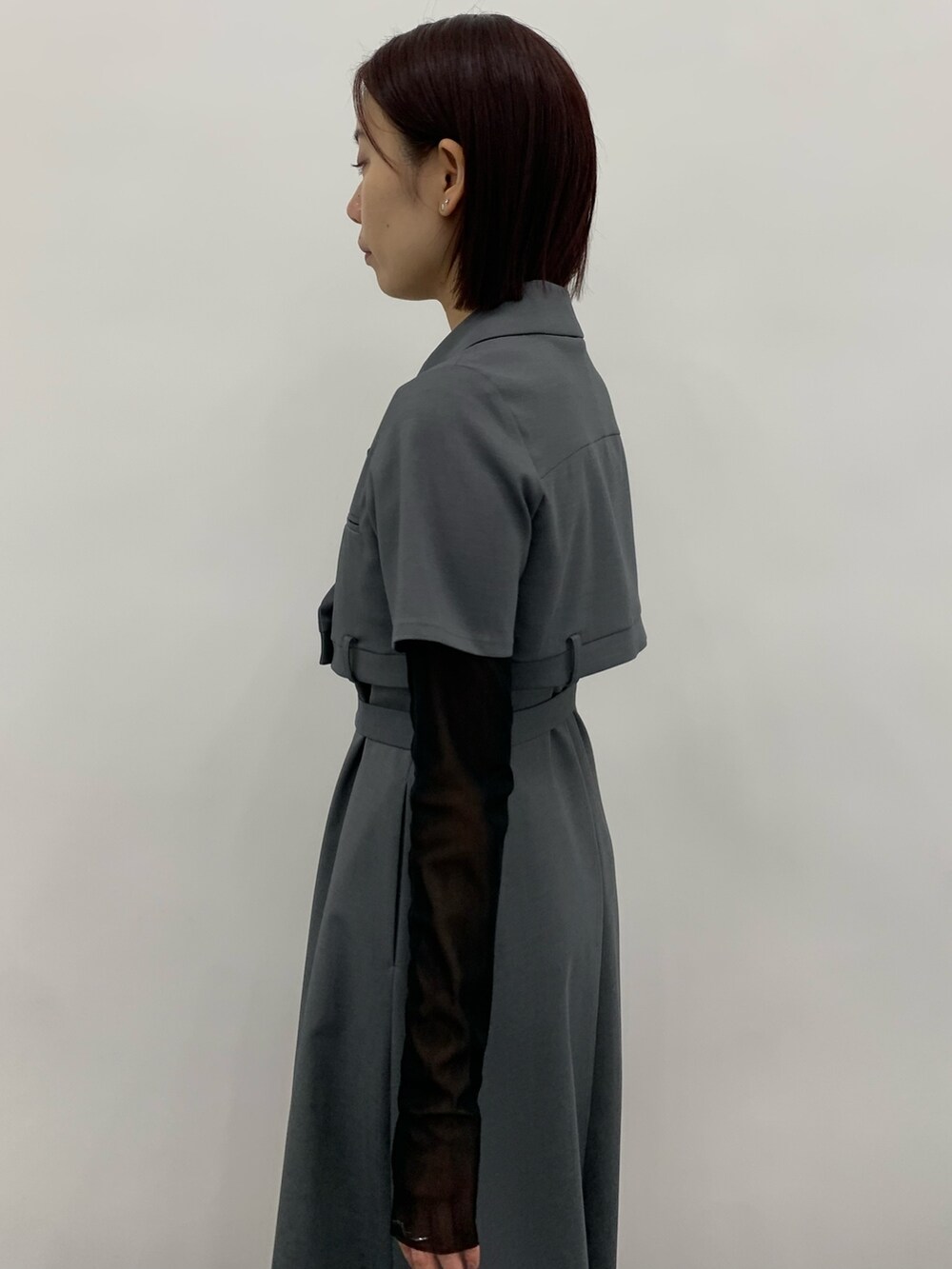 グレー系のワンピース、ブラック系のTシャツ/カットソー、ホワイト系のシューズを着用したレディースの秋コーディネートの5枚目の写真