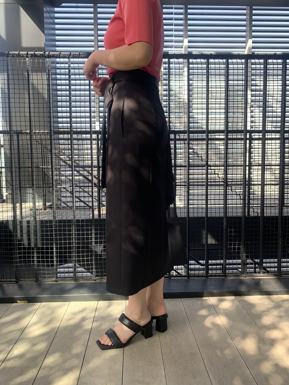 ピンク系のニット/セーター、ブラック系のスカート、ブラック系のその他シューズを着用したレディースの春コーディネートの7枚目の写真