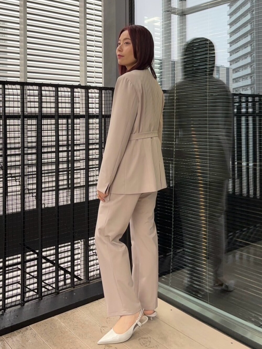 ブルー系のニット/セーター、ベージュ系のスラックス、ベージュ系のセットアップを着用したレディースの冬コーディネートの2枚目の写真