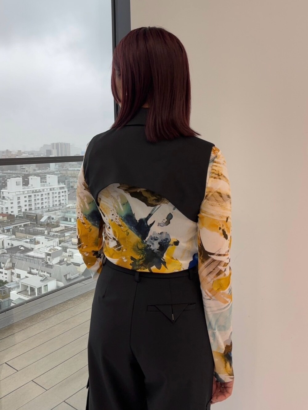 ブラック系のジャンパースカート、ブラック系のカーゴパンツ、イエロー系のTシャツ/カットソーを着用したレディースの冬コーディネートの7枚目の写真