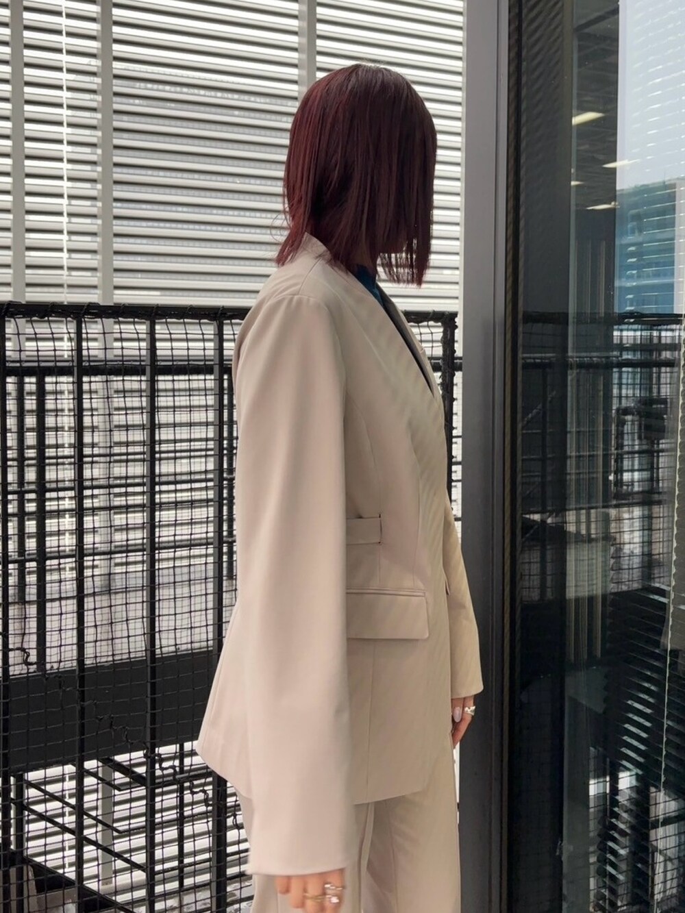 ブルー系のニット/セーター、ベージュ系のスラックス、ベージュ系のセットアップを着用したレディースの冬コーディネートの10枚目の写真