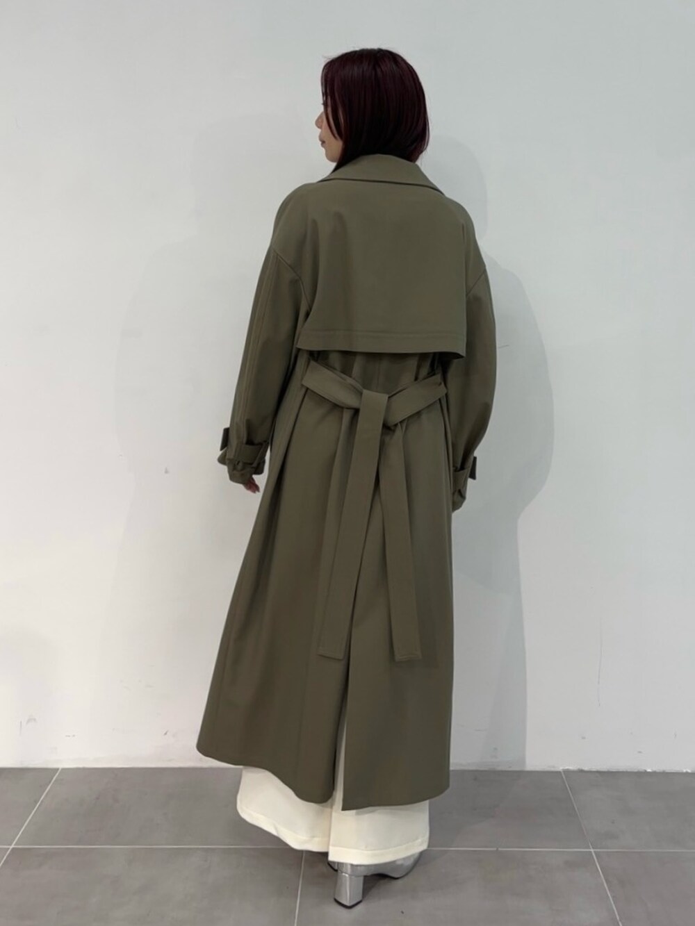 ブラウン系のトレンチコートを着用したレディースの冬コーディネートの3枚目の写真