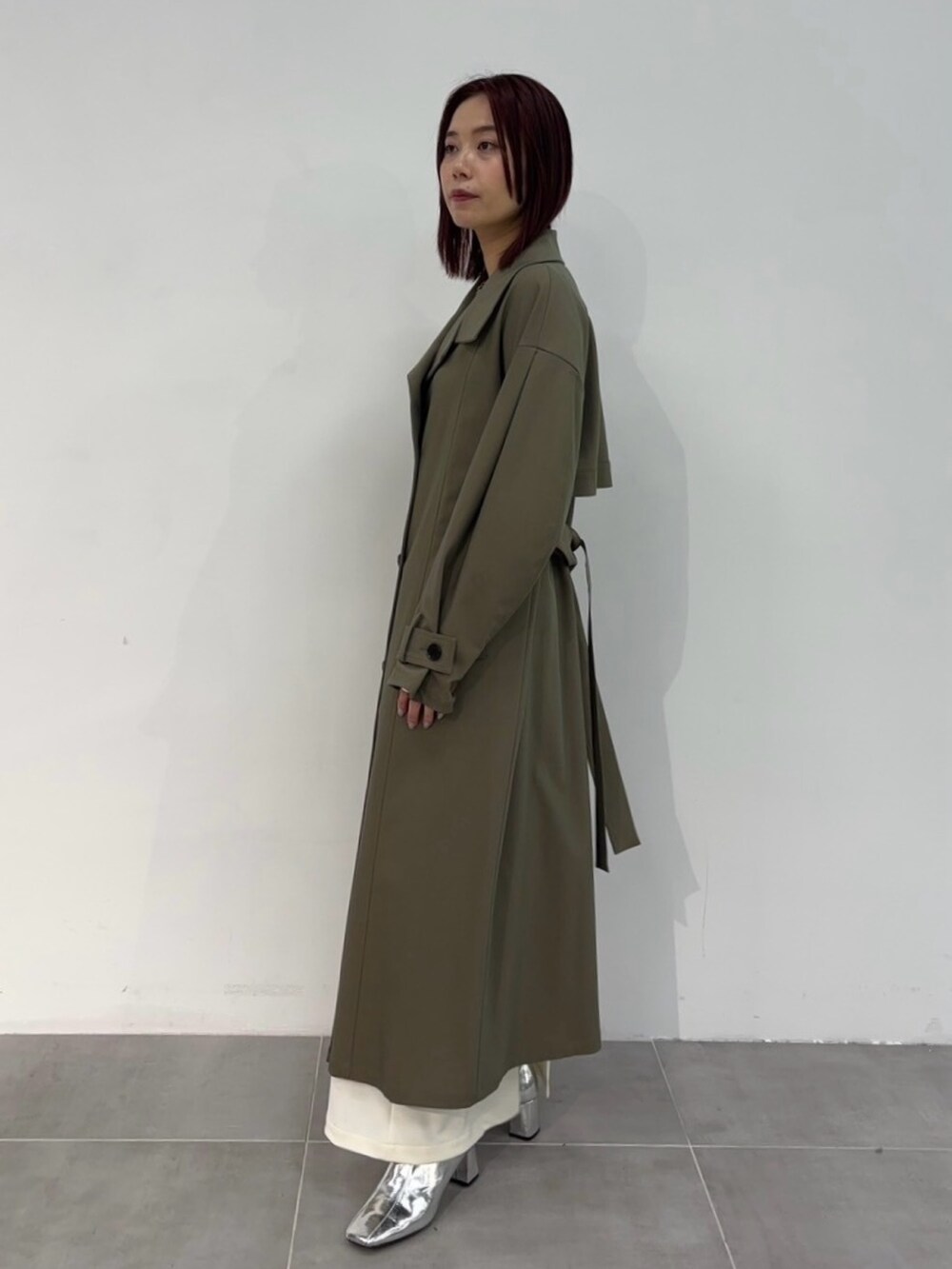 ブラウン系のトレンチコートを着用したレディースの冬コーディネートの2枚目の写真