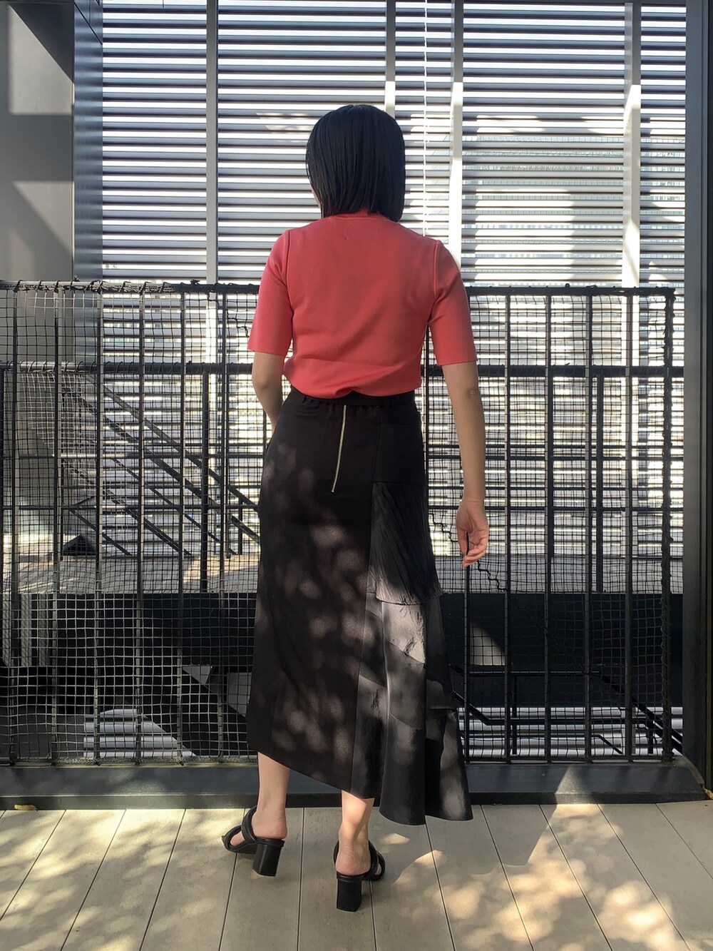 ピンク系のニット/セーター、ブラック系のスカート、ブラック系のその他シューズを着用したレディースの春コーディネートの3枚目の写真