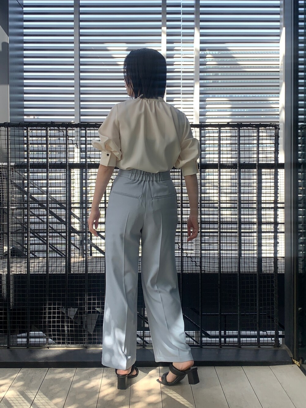 ホワイト系のシャツ/ブラウス、ブルー系のスラックス、ブラック系のその他シューズを着用したレディースの春コーディネートの2枚目の写真