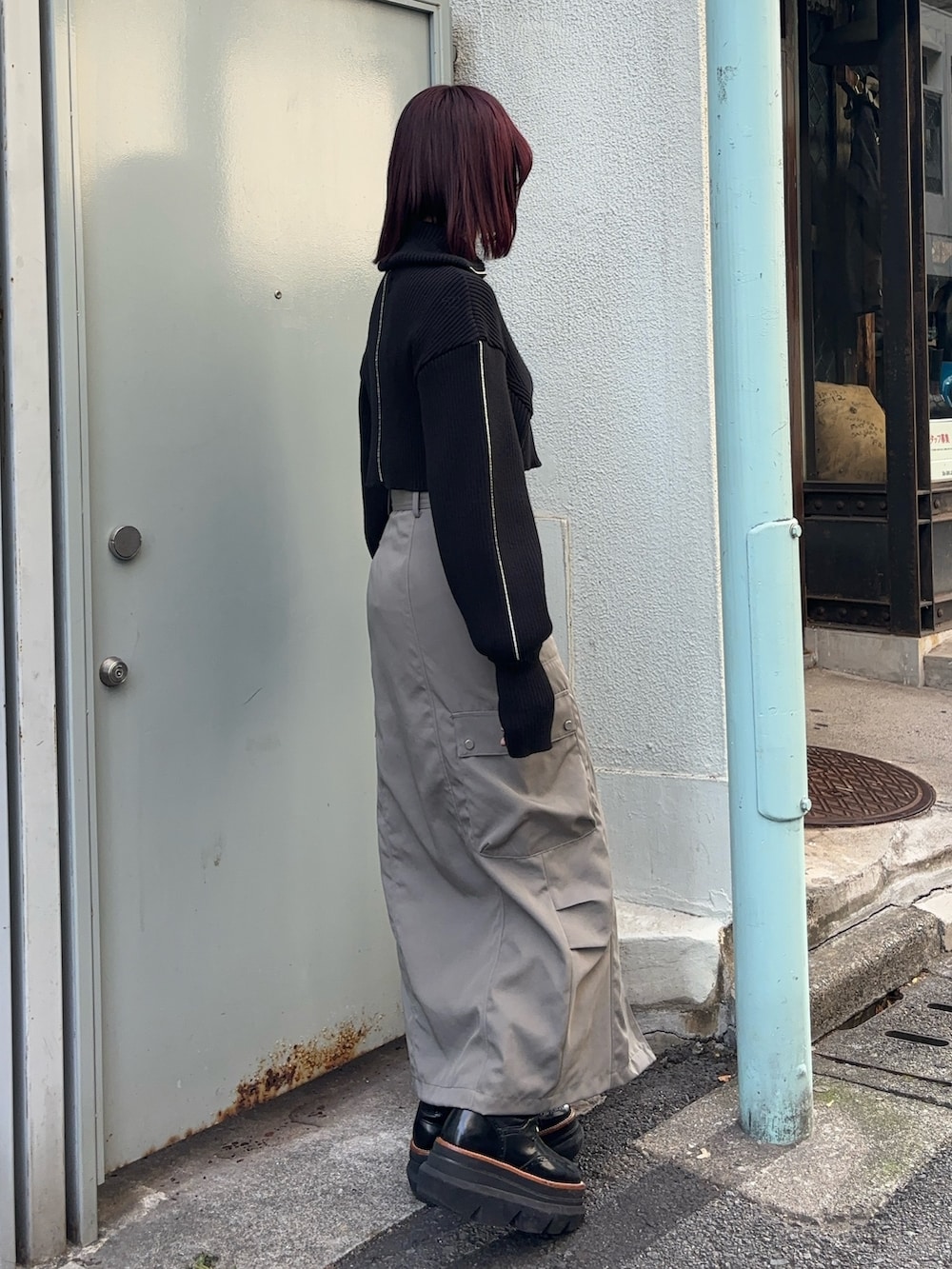 ブラック系のニット/セーター、ブラウン系のTシャツ/カットソー、グレー系のスカートを着用したレディースの冬コーディネートの3枚目の写真