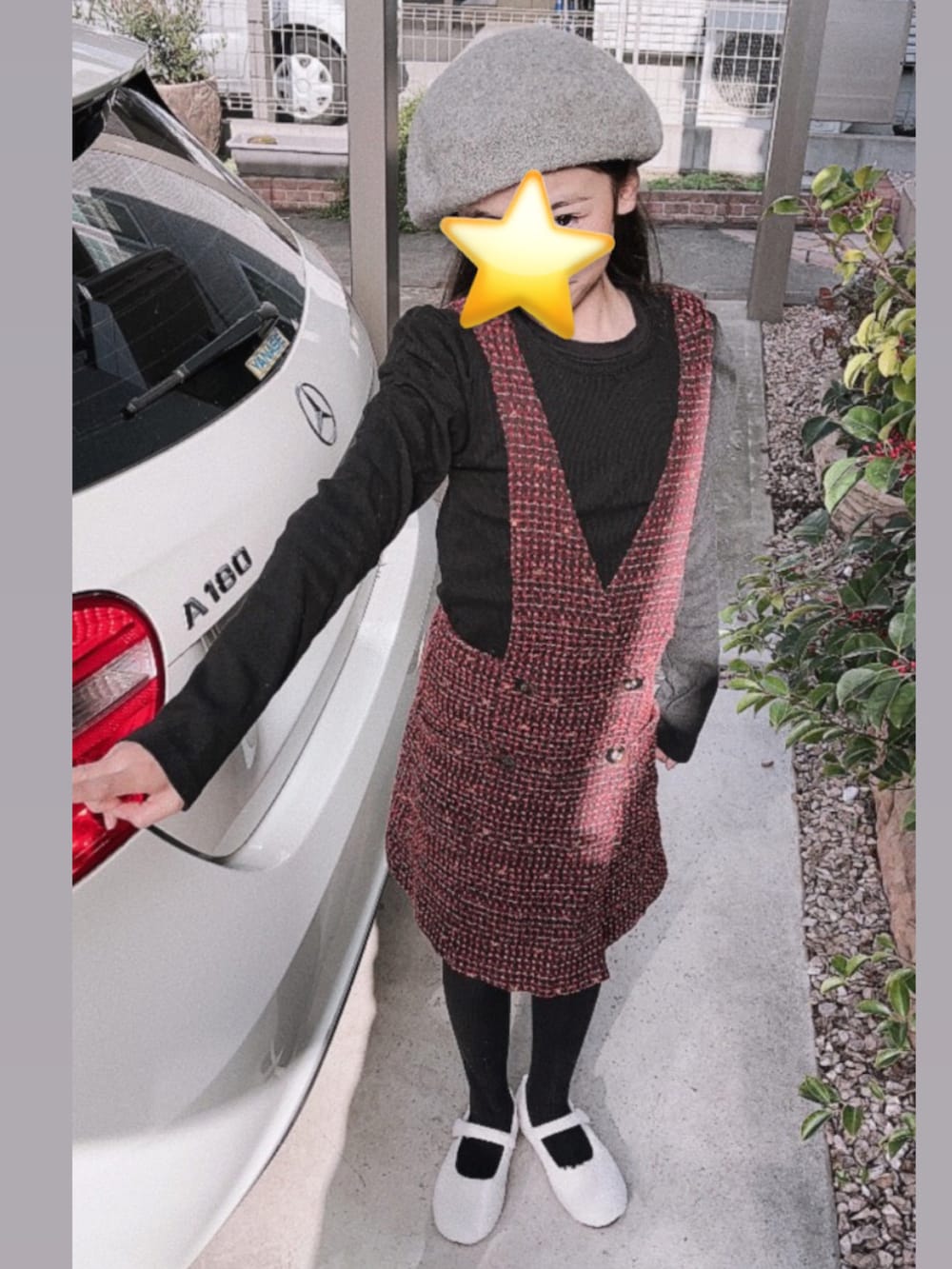 ホワイト系のバレエシューズ、レッド系のジャンパースカートを着用したキッズの冬コーディネートの2枚目の写真