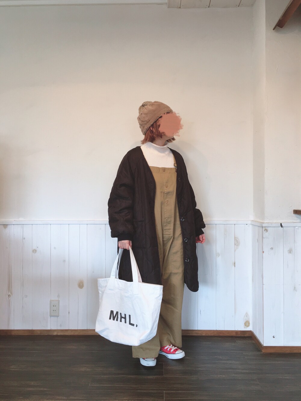 ホワイト系のトートバッグ、ベージュ系のニット/セーター、ベージュ系のサロペット/オーバーオールを着用したレディースの冬コーディネートの2枚目の写真