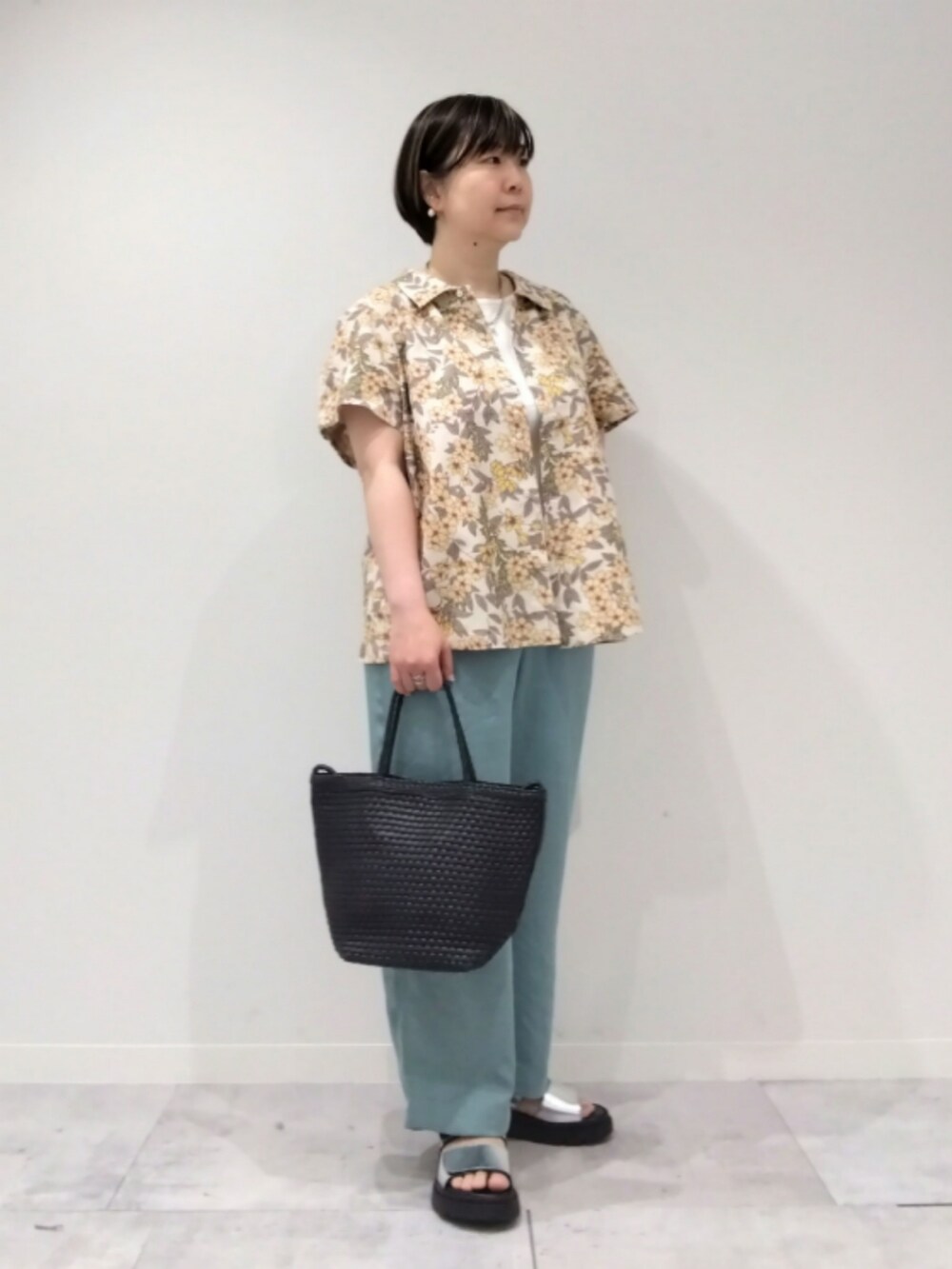 イエロー系のシャツ/ブラウス、グリーン系のその他パンツ、ブラック系のトートバッグを着用したレディースの春コーディネートの2枚目の写真