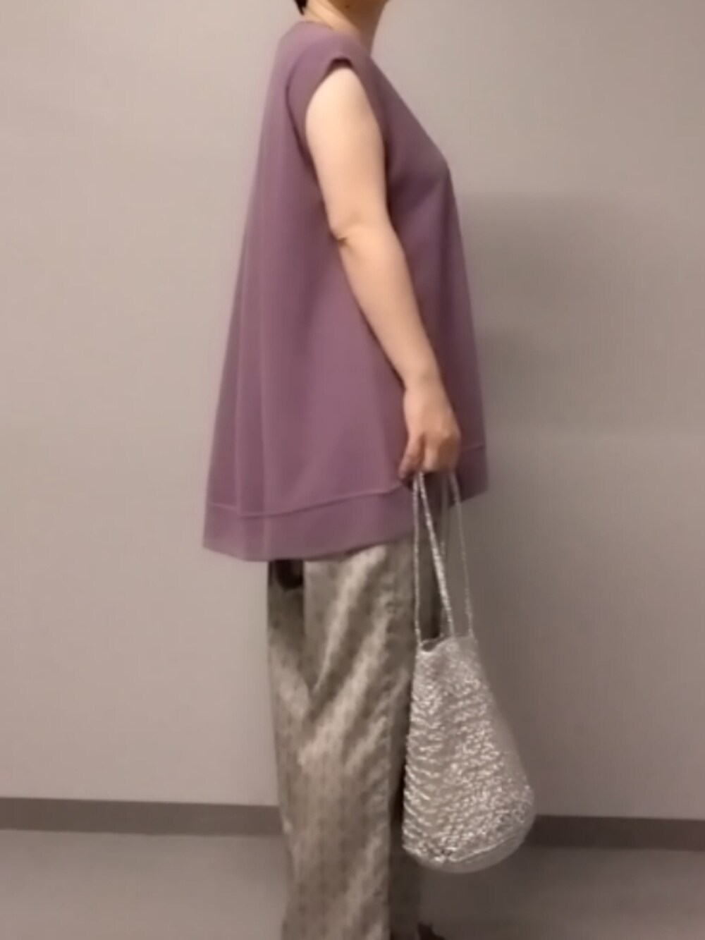 パープル系のTシャツ/カットソー、ベージュ系のその他パンツ、シルバー系のかごバッグを着用したレディースの夏コーディネートの3枚目の写真