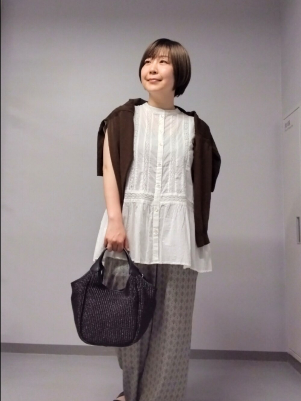 ホワイト系のシャツ/ブラウス、ブラウン系のカーディガン/ボレロ、ベージュ系のその他パンツを着用したレディースの春コーディネートの3枚目の写真