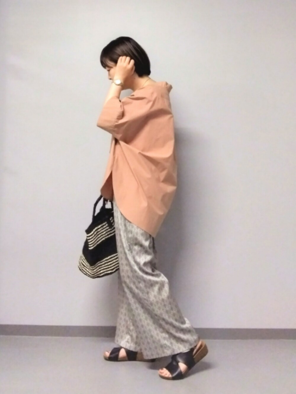 ベージュ系のその他パンツ、ブラック系のかごバッグ、ピンク系のシャツ/ブラウスを着用したレディースの夏コーディネートの3枚目の写真