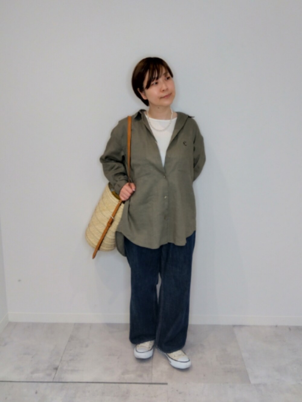 グレー系のシャツ/ブラウス、ブルー系のデニムパンツを着用したレディースの春コーディネートの2枚目の写真