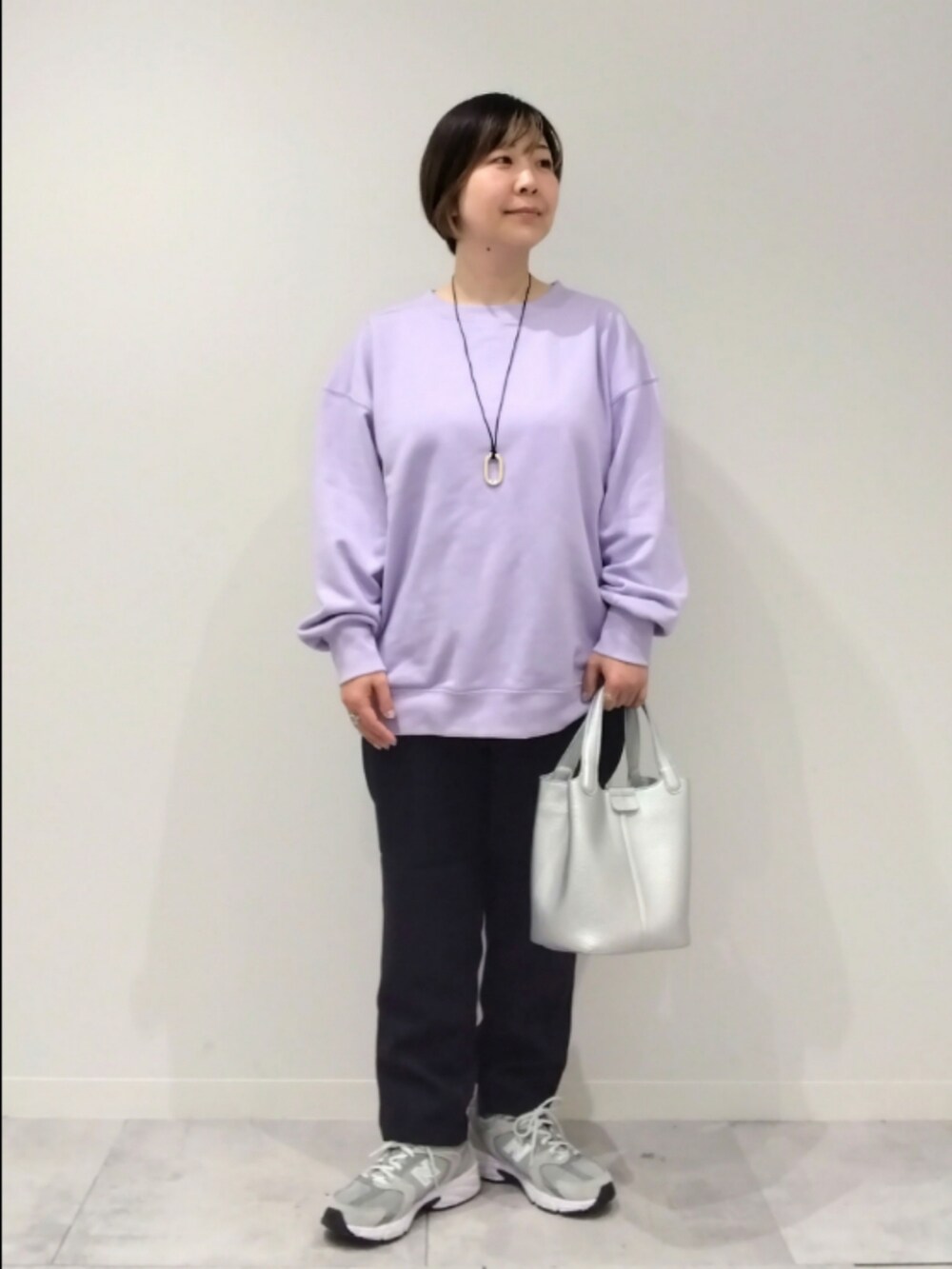 パープル系のスウェット、シルバー系のトートバッグ、ブラック系のその他パンツを着用したレディースの春コーディネートの2枚目の写真