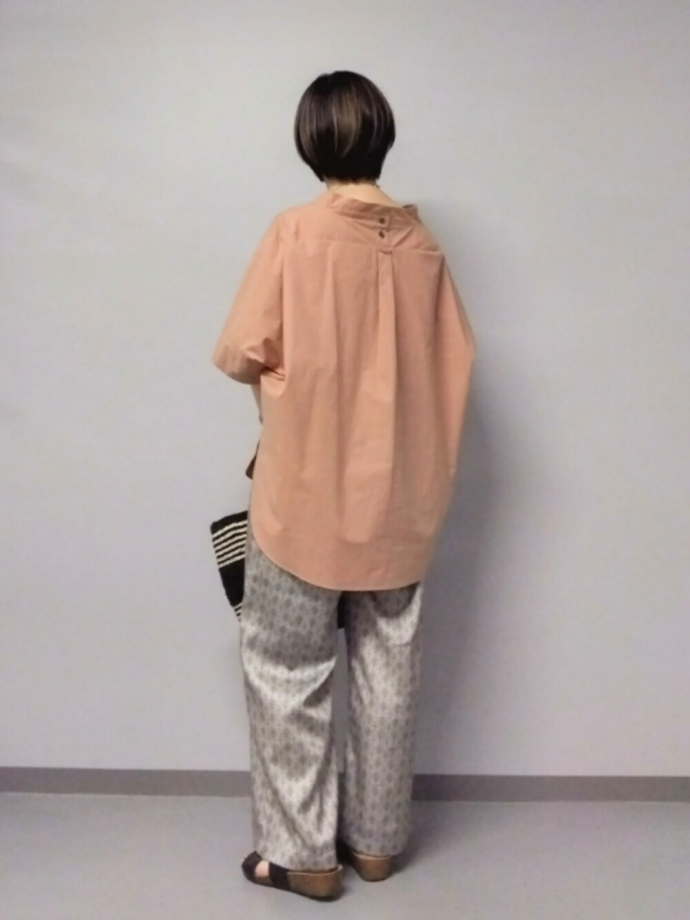 ベージュ系のその他パンツ、ブラック系のかごバッグ、ピンク系のシャツ/ブラウスを着用したレディースの夏コーディネートの4枚目の写真