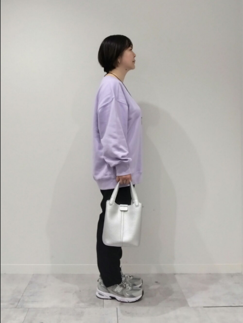 パープル系のスウェット、シルバー系のトートバッグ、ブラック系のその他パンツを着用したレディースの春コーディネートの3枚目の写真