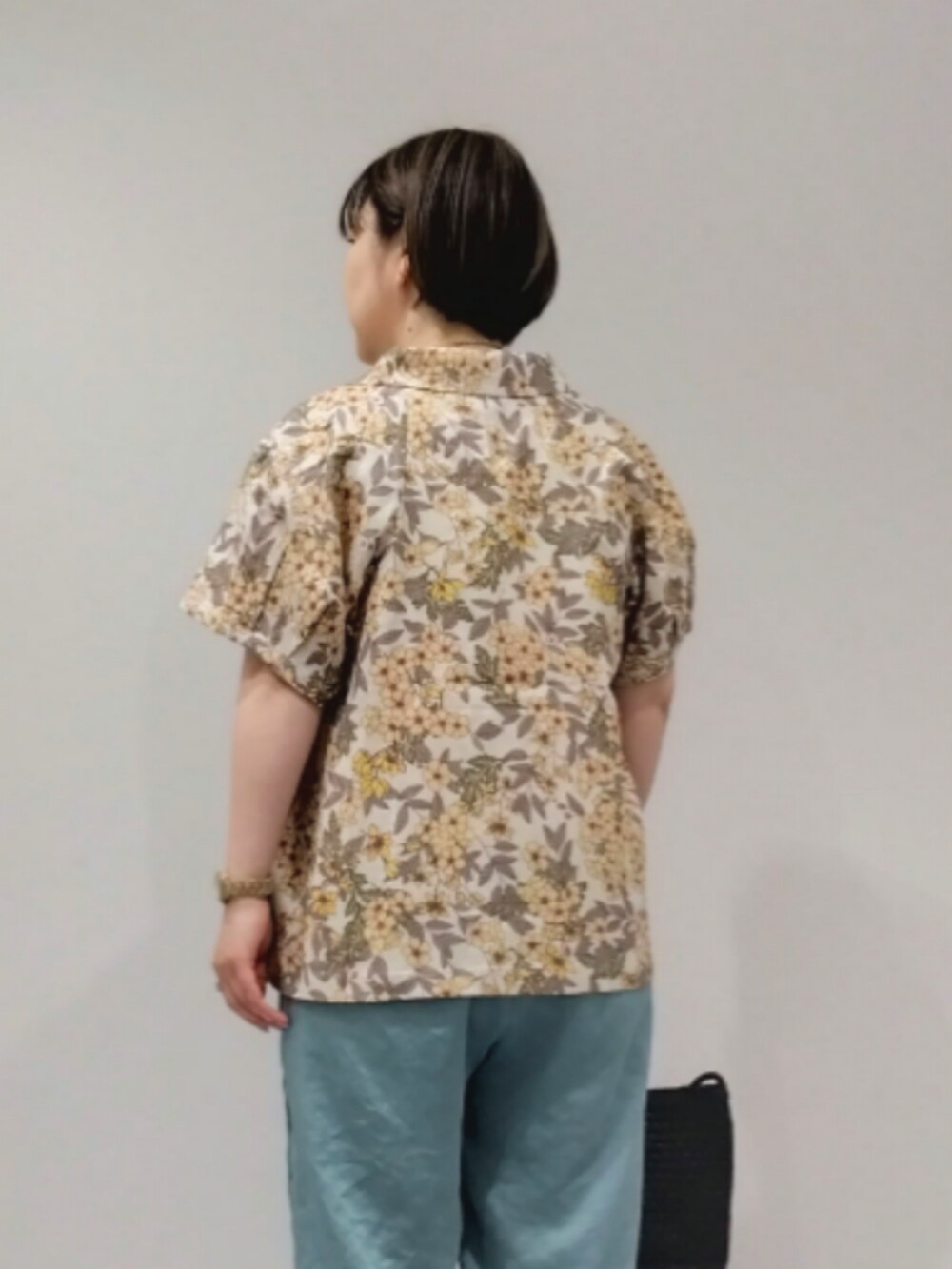 イエロー系のシャツ/ブラウス、グリーン系のその他パンツ、ブラック系のトートバッグを着用したレディースの春コーディネートの4枚目の写真