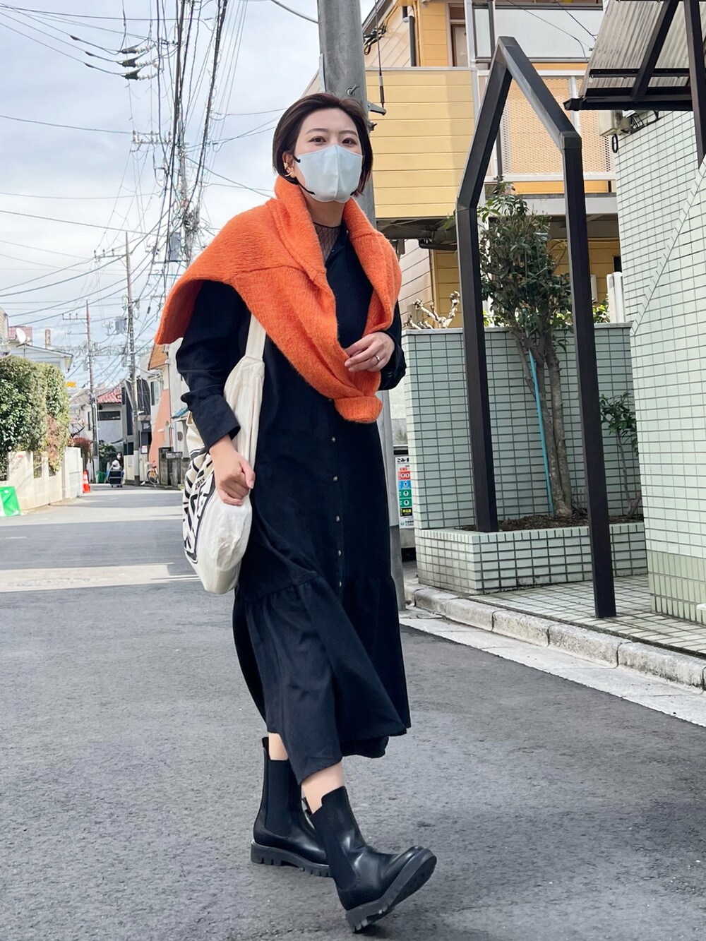 ブラック系のブーツ、ブラック系のワンピースを着用したレディースの春コーディネートの2枚目の写真