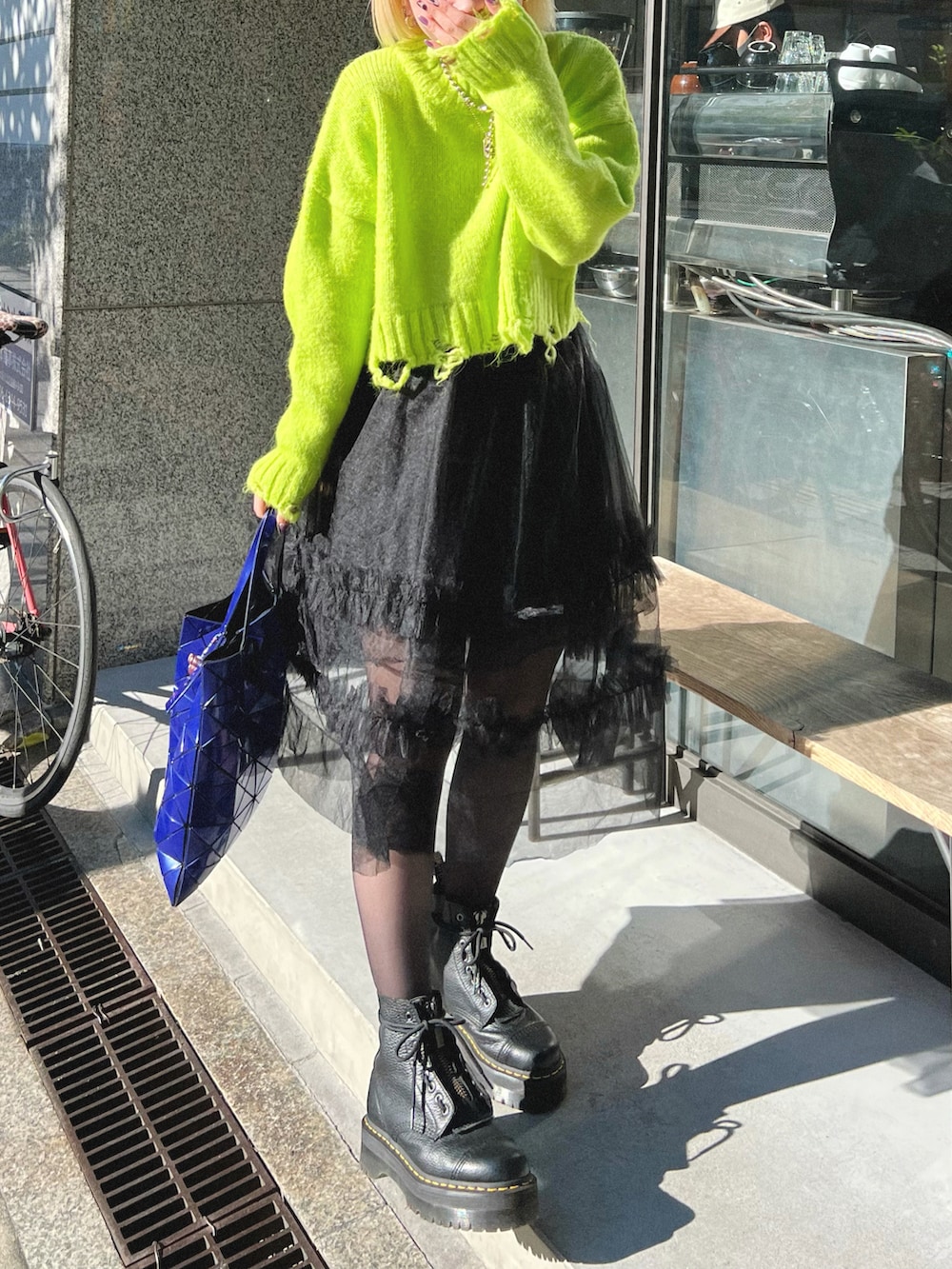 ブルー系のトートバッグ、ブラック系のブーツを着用したレディースの秋コーディネートの3枚目の写真