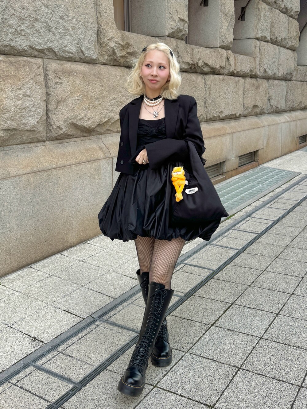 ブラック系のショルダーバッグ、ブラック系のブーツ、ブラック系のワンピースを着用したレディースの春コーディネートの2枚目の写真