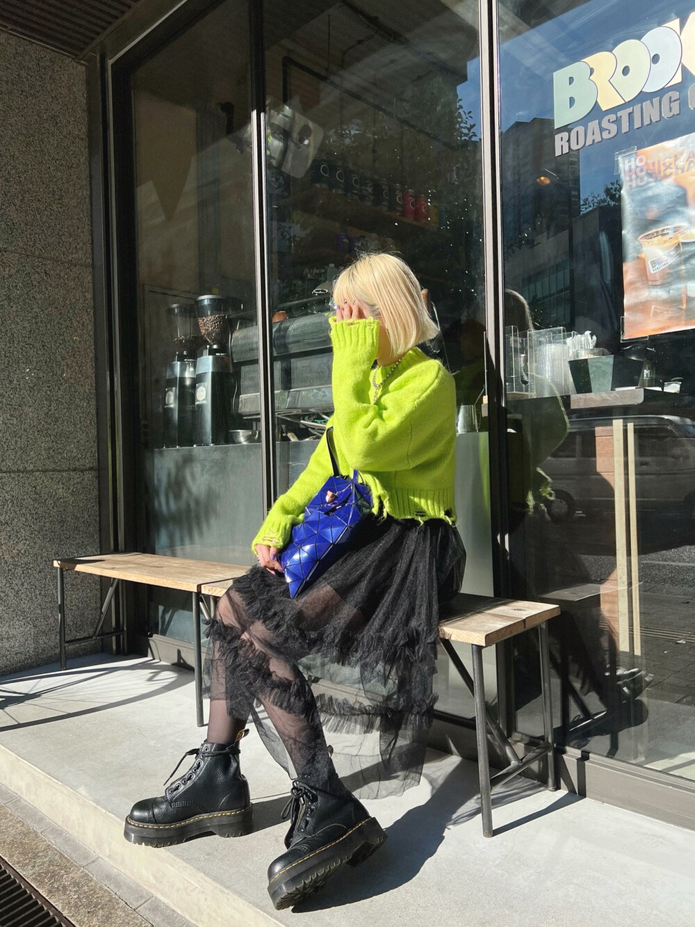 ブルー系のトートバッグ、ブラック系のブーツを着用したレディースの秋コーディネートの2枚目の写真