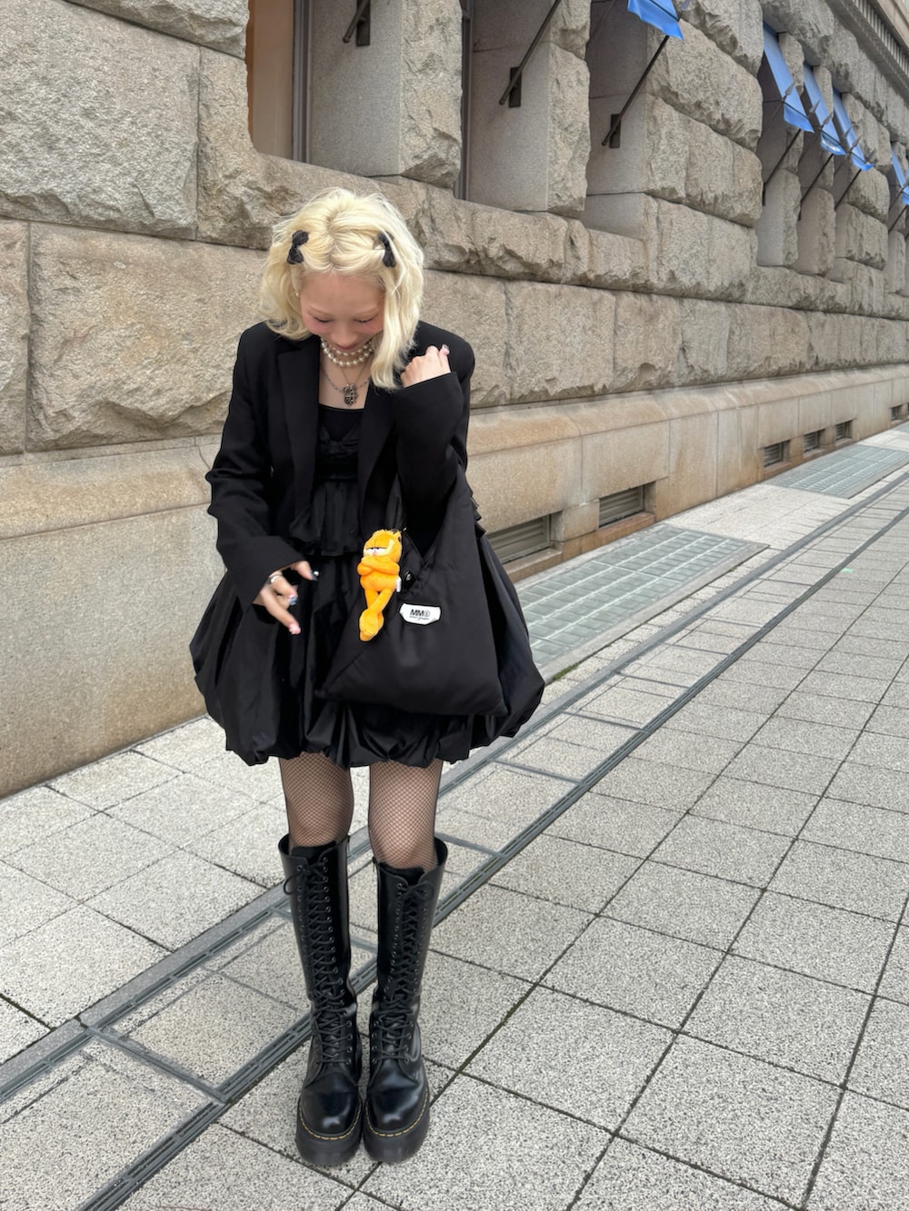 ブラック系のショルダーバッグ、ブラック系のブーツ、ブラック系のワンピースを着用したレディースの春コーディネートの3枚目の写真