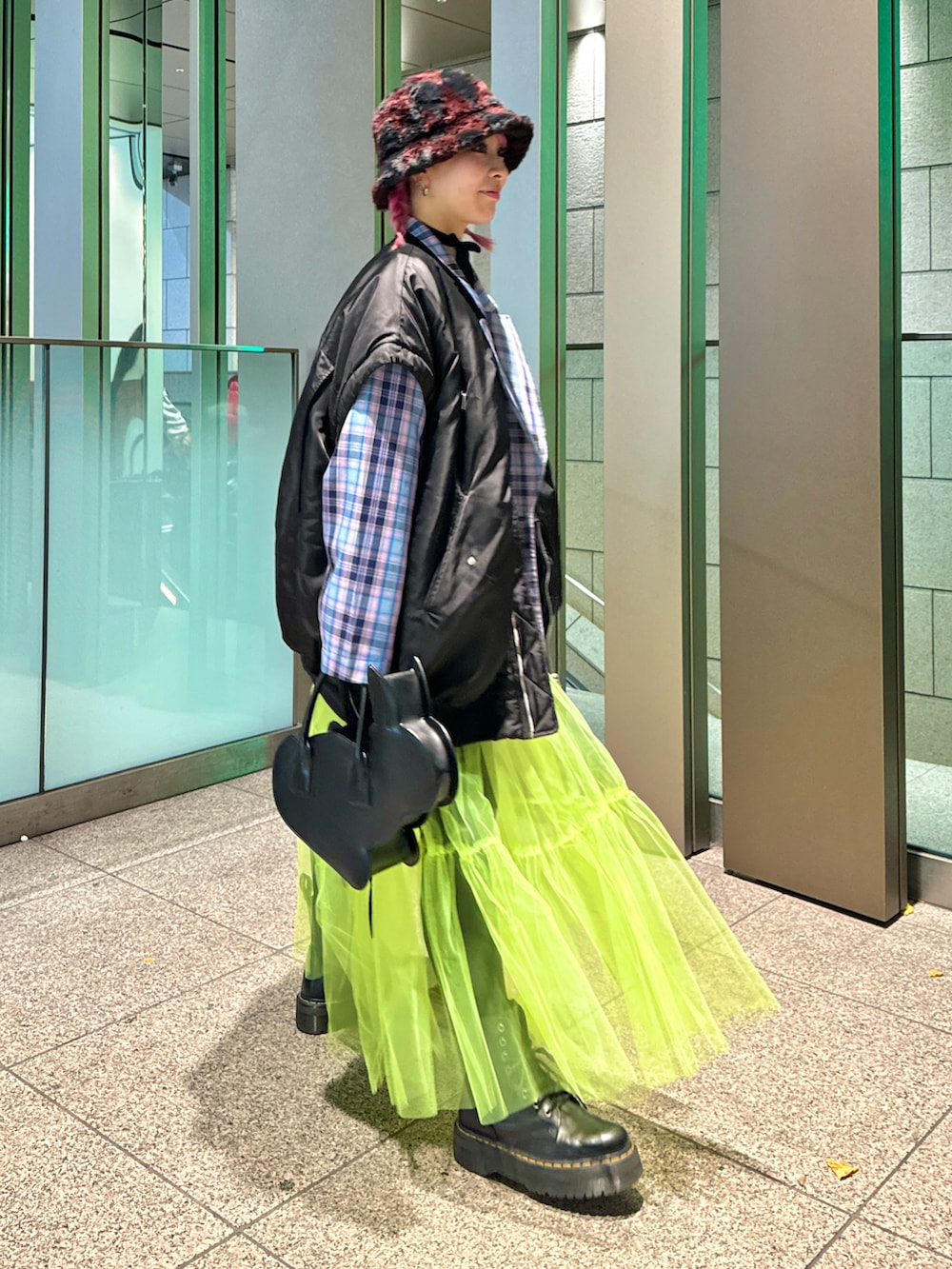 ブラック系のMA-1、ピンク系のテーラードジャケット、イエロー系のスカートを着用したレディースの冬コーディネートの3枚目の写真