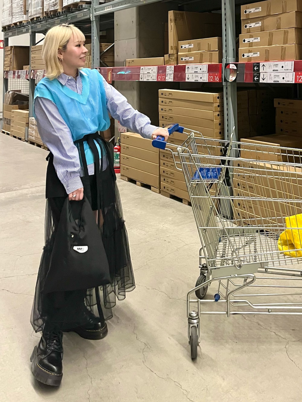 ホワイト系のベスト、ブルー系のシャツ/ブラウス、ブラック系のスカートを着用したレディースの春コーディネートの3枚目の写真