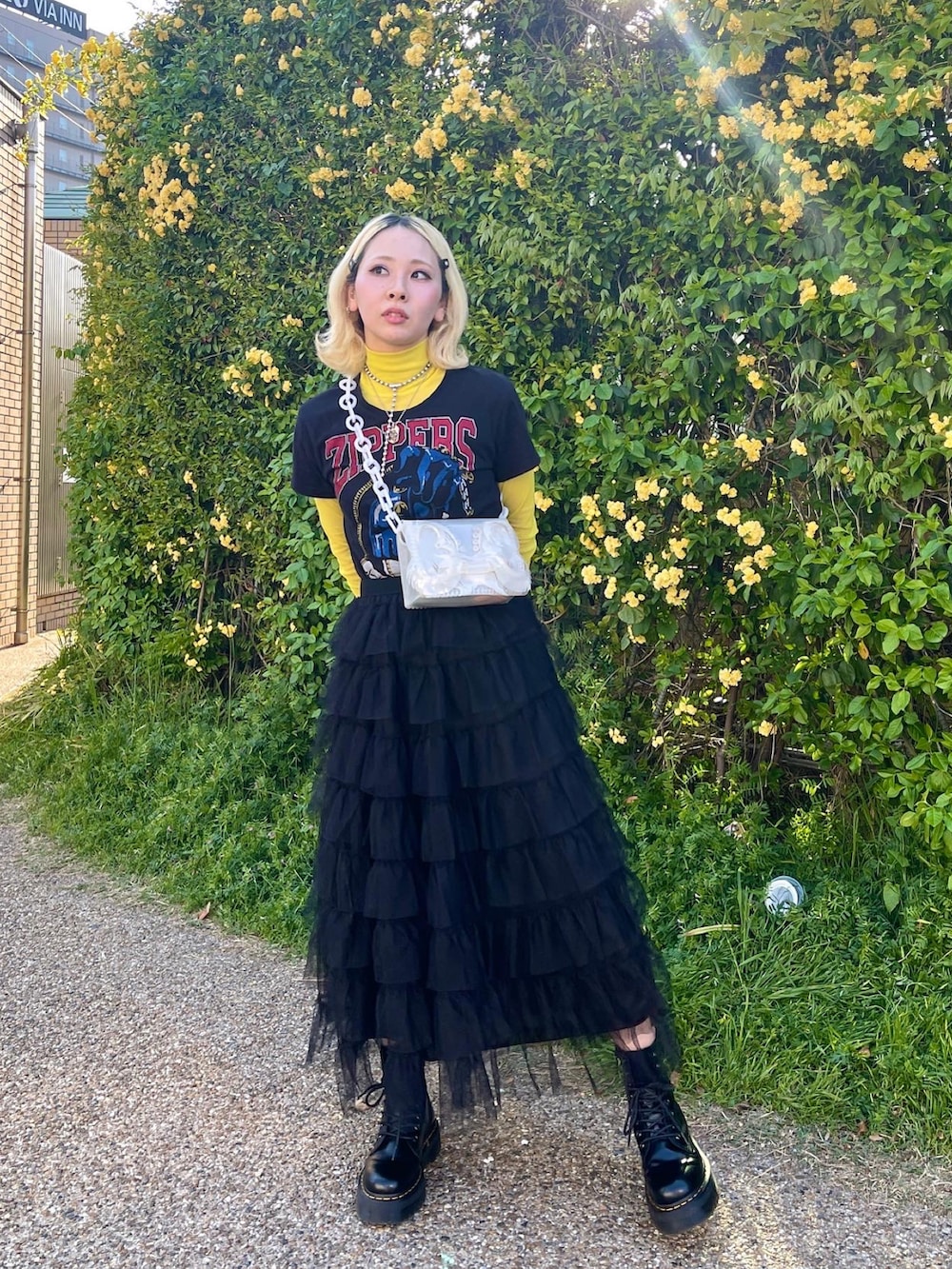 ブラック系のスカート、ホワイト系のハンドバッグ、ブラック系のTシャツ/カットソーを着用したレディースの春コーディネートの3枚目の写真