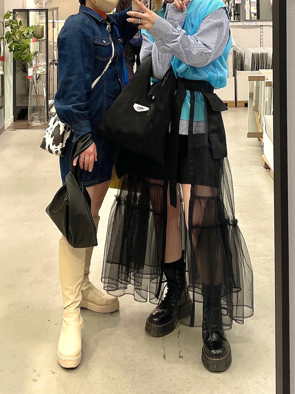 ホワイト系のベスト、ブルー系のシャツ/ブラウス、ブラック系のスカートを着用したレディースの春コーディネートの2枚目の写真