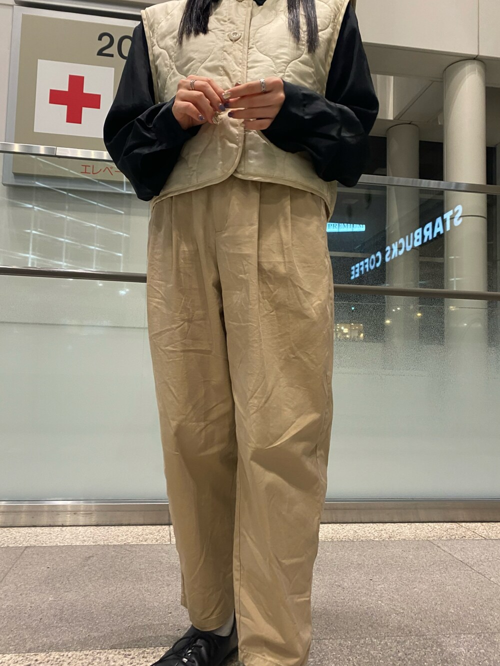 ベージュ系のチノパンツ、ベージュ系のベストを着用したレディースの秋コーディネートの3枚目の写真