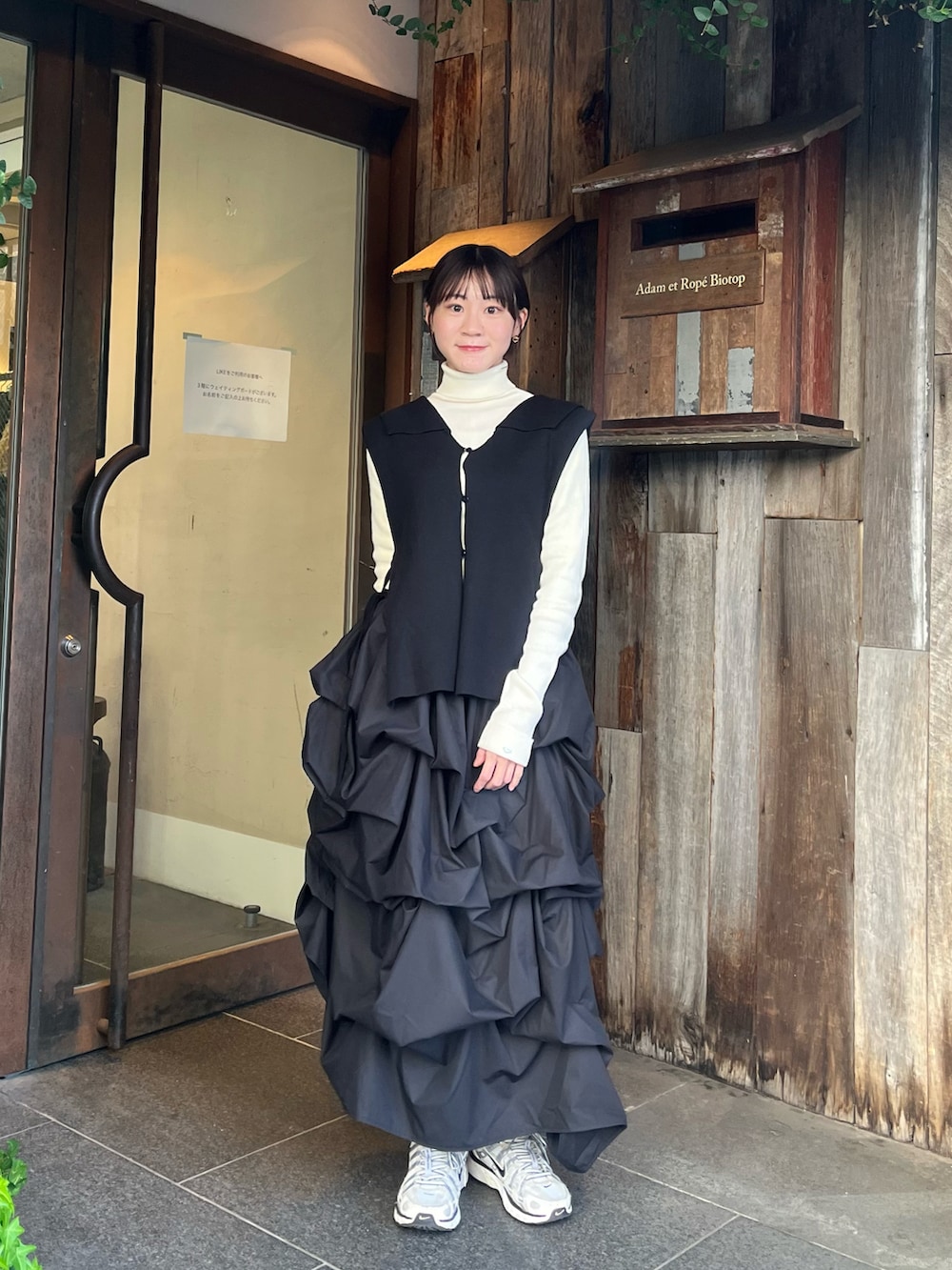 ホワイト系のハンドバッグ、ブラック系のスカート、ホワイト系のニット/セーターを着用したレディースの秋コーディネートの3枚目の写真