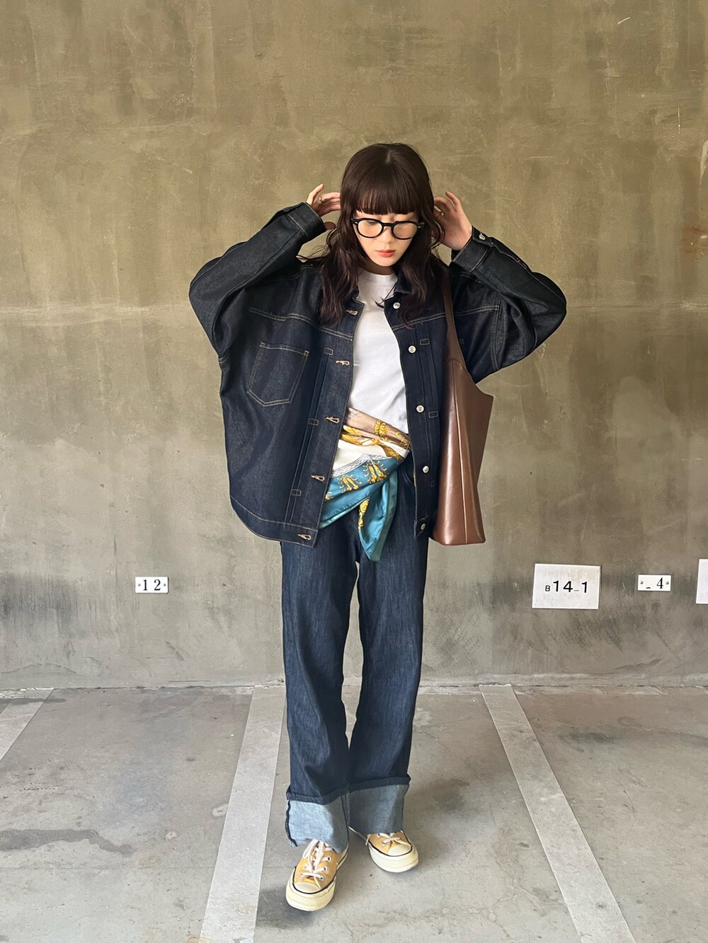 ホワイト系のTシャツ/カットソー、ブルー系のデニムジャケット、ブラウン系のバッグを着用したレディースの秋コーディネートの2枚目の写真