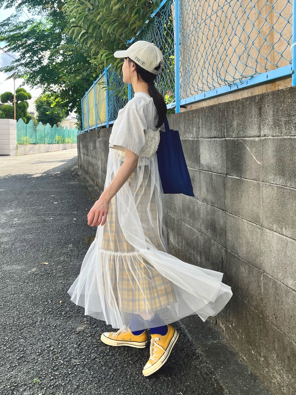 ベージュ系のTシャツ/カットソー、ホワイト系のキャミソール、イエロー系のスニーカーを着用したレディースの秋コーディネートの2枚目の写真