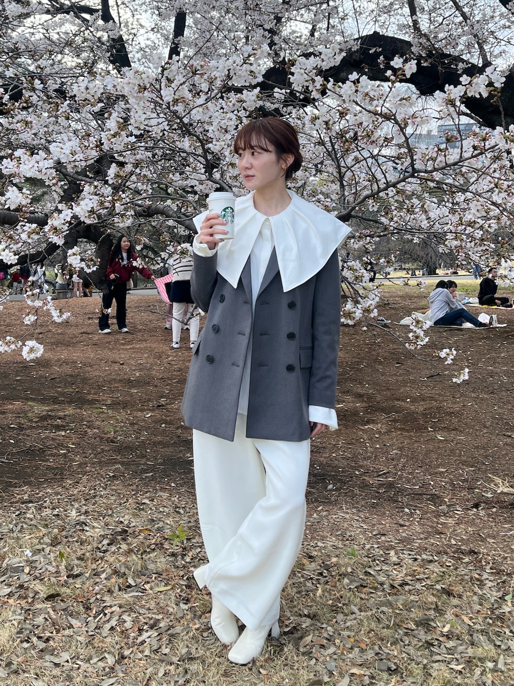 ホワイト系のブーツ、ホワイト系のスラックス、グレー系のジャケット/アウターを着用したレディースの春コーディネートの2枚目の写真