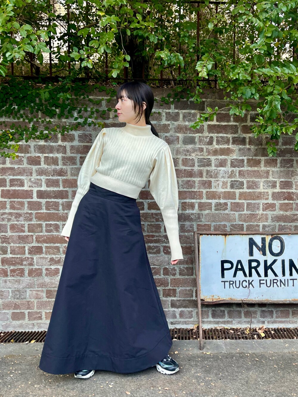 ブラック系のスカート、ホワイト系のニット/セーターを着用したレディースの秋コーディネートの2枚目の写真