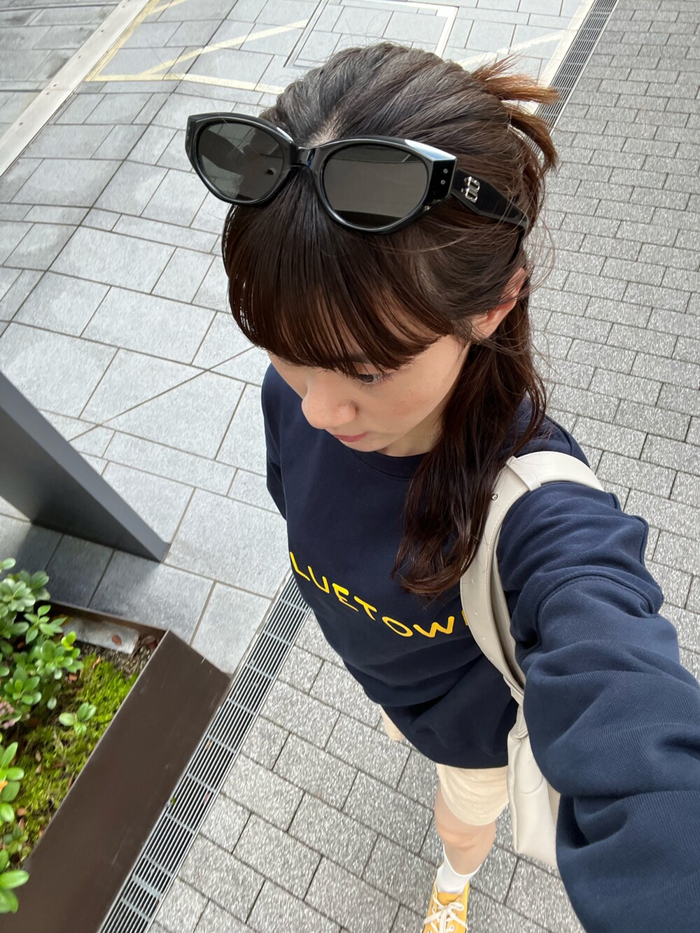 ブルー系のスウェット、ベージュ系のショルダーバッグ、ホワイト系のその他パンツを着用したレディースの秋コーディネートの3枚目の写真