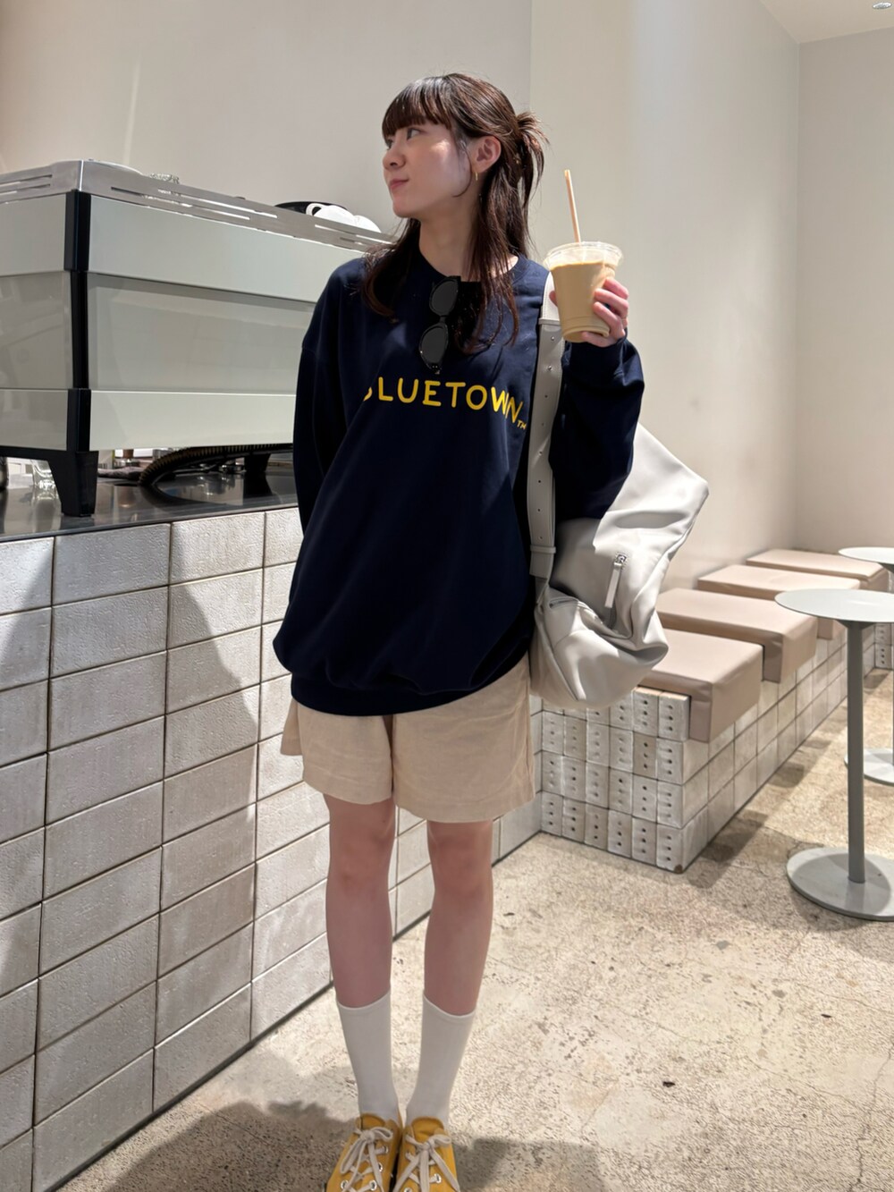 ブルー系のスウェット、ベージュ系のショルダーバッグ、ホワイト系のその他パンツを着用したレディースの秋コーディネートの2枚目の写真