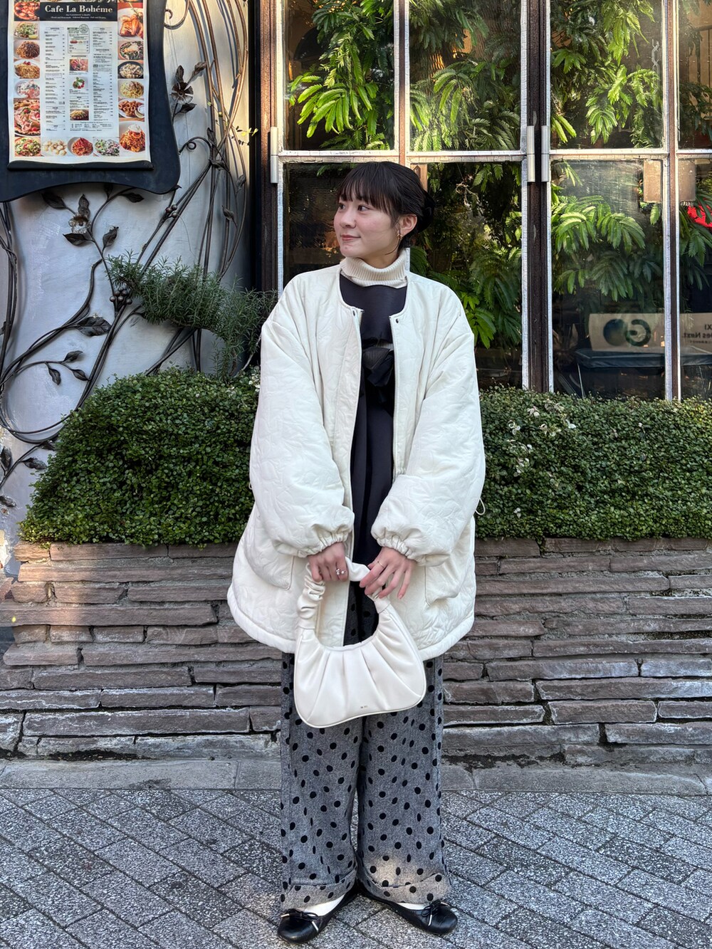 ブラック系のスウェット、ブラック系のパンツ、ホワイト系のジャケット/アウターを着用したレディースの冬コーディネートの2枚目の写真