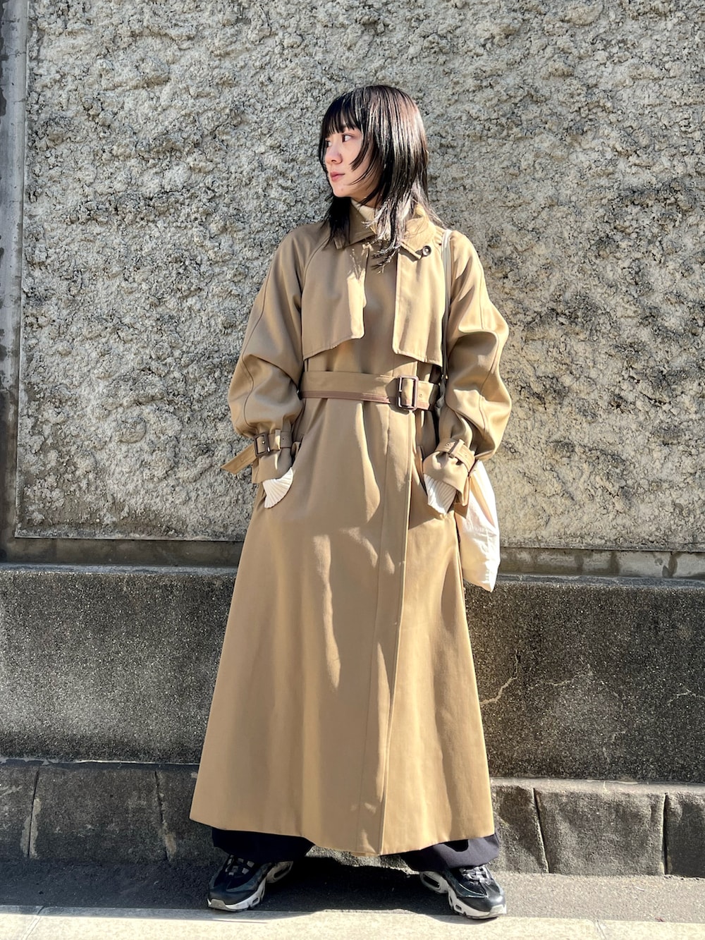 ブラック系のその他パンツ、ベージュ系のトレンチコートを着用したレディースの冬コーディネートの2枚目の写真