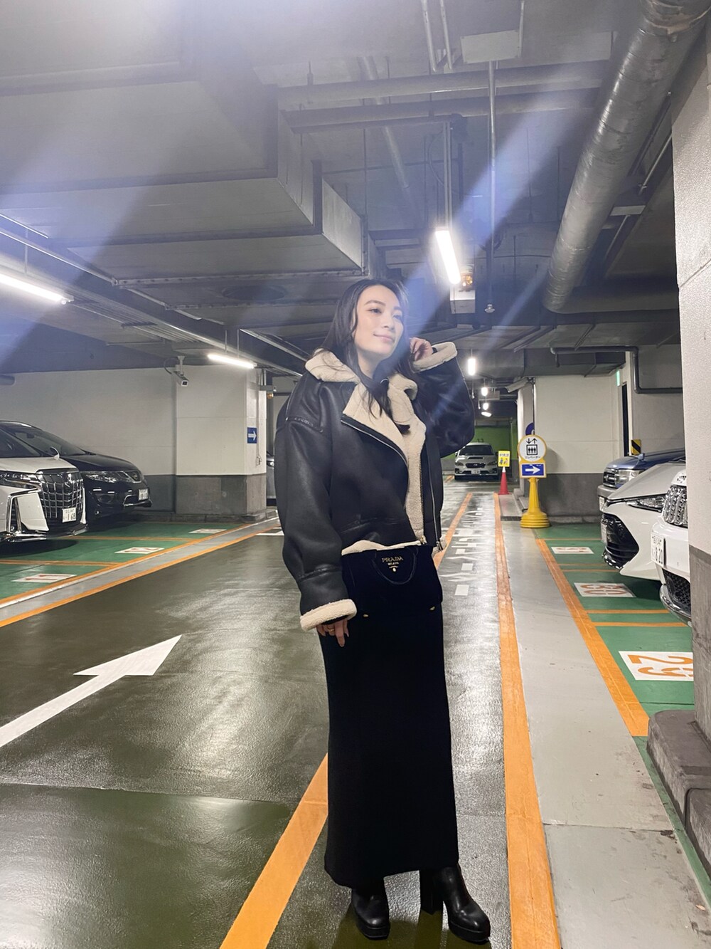 ブラック系のブルゾン、ブラック系のスカート、ブラック系のニット/セーターを着用したレディースの冬コーディネートの2枚目の写真