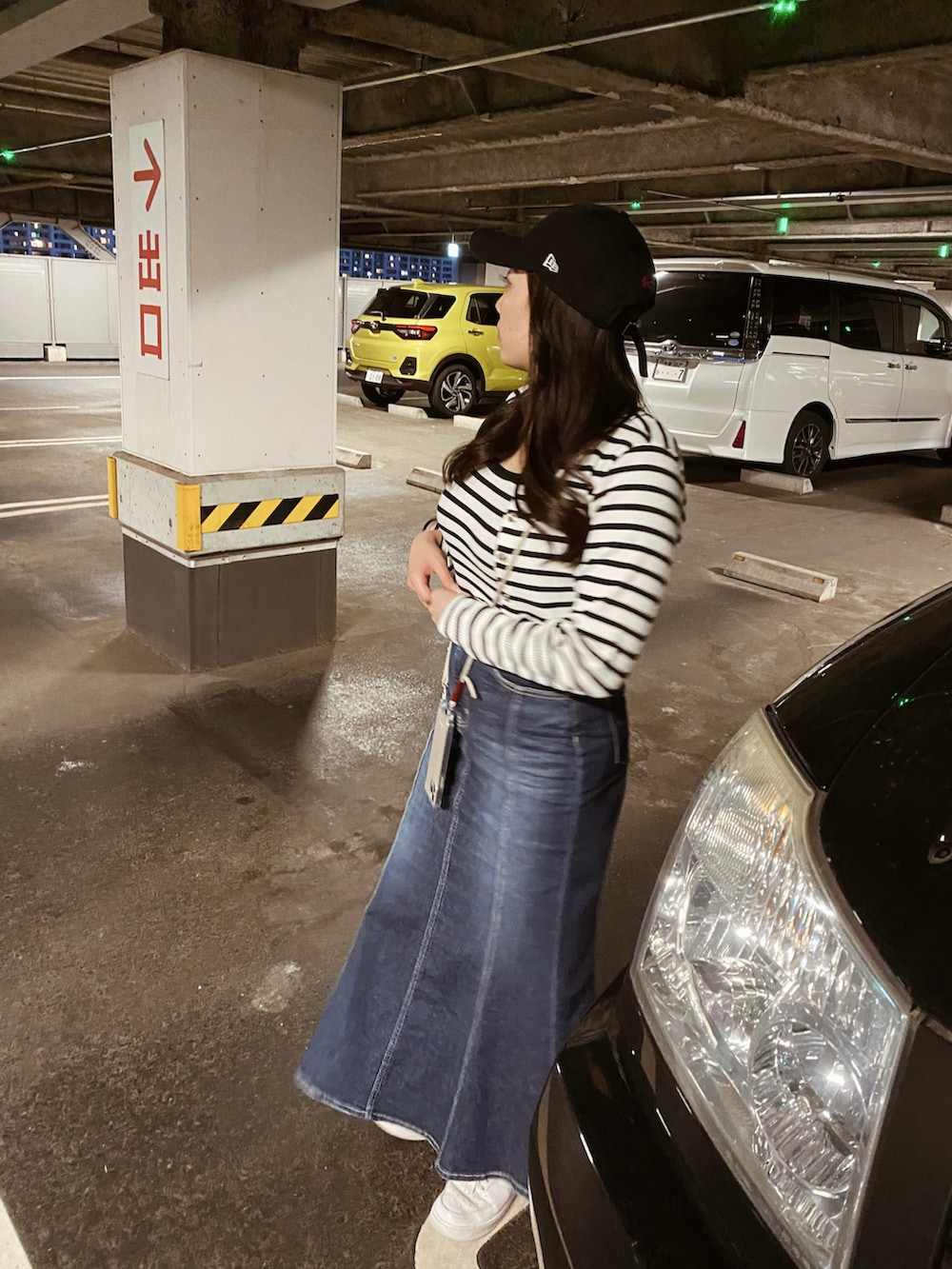 ホワイト系のスニーカー、ブルー系のデニムスカート、ホワイト系のアンサンブルを着用したレディースの夏コーディネートの3枚目の写真