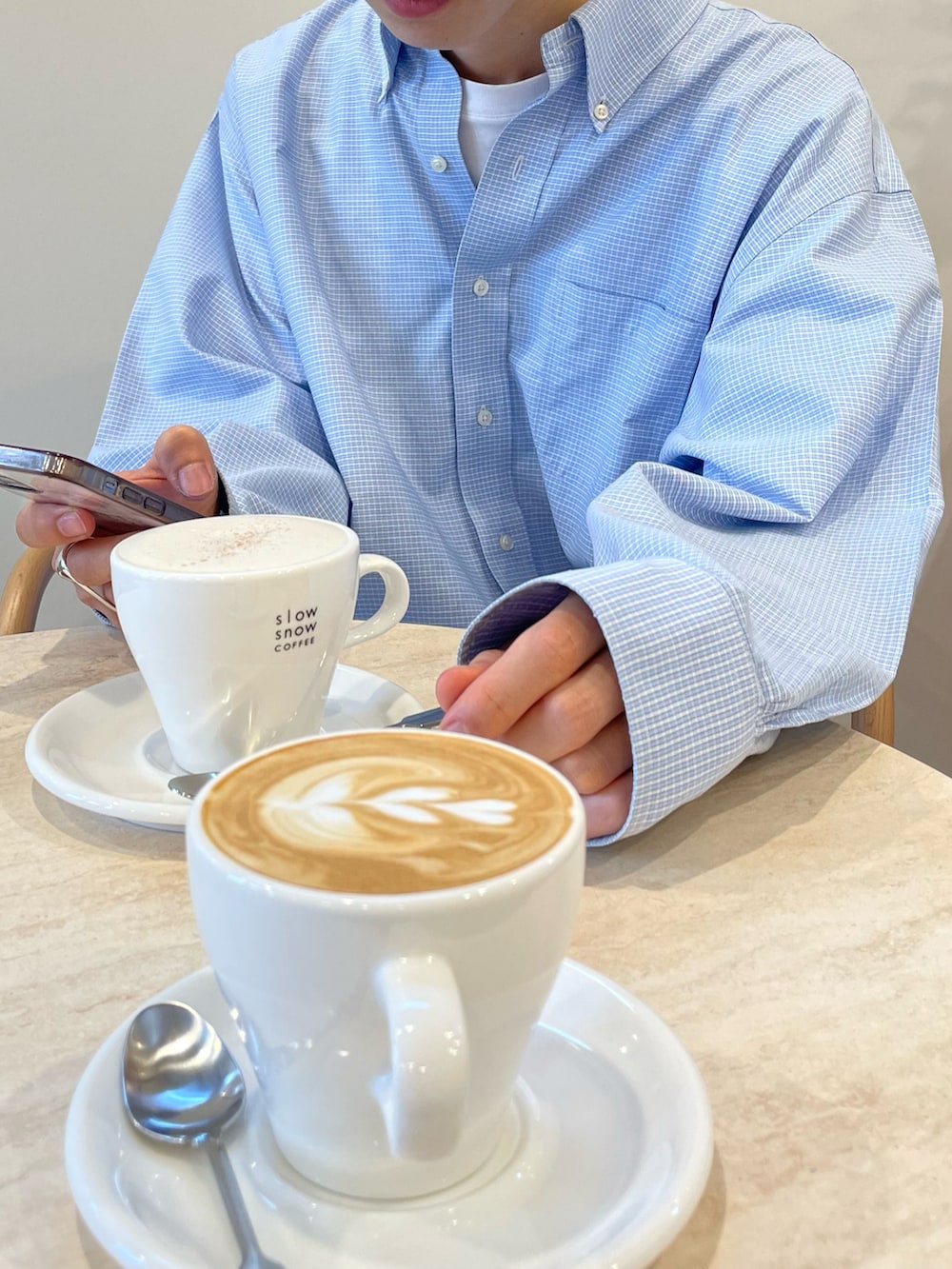 ベージュ系のスウェットパンツ、ブルー系のシャツ/ブラウス、ベージュ系のスニーカーを着用したメンズの秋コーディネートの2枚目の写真