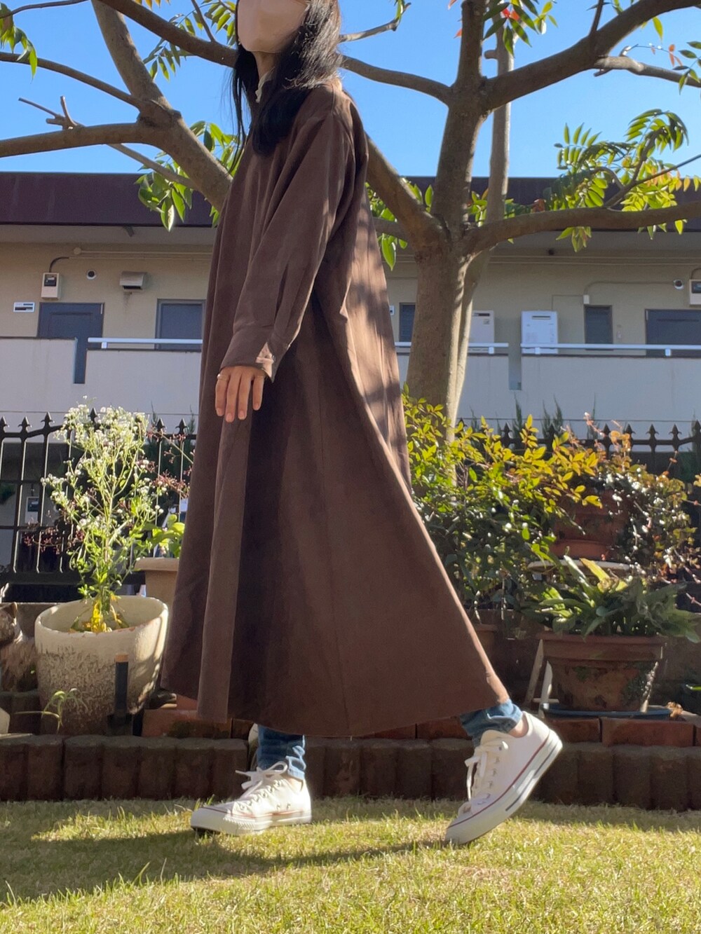 ベージュ系のショルダーバッグ、ブラウン系のシャツワンピース、ホワイト系のその他トップスを着用したレディースの秋コーディネートの2枚目の写真