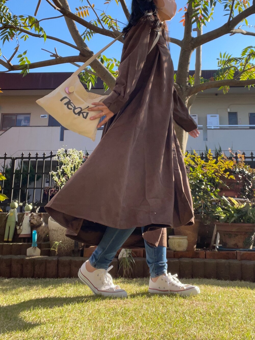 ベージュ系のショルダーバッグ、ブラウン系のシャツワンピース、ホワイト系のその他トップスを着用したレディースの秋コーディネートの3枚目の写真