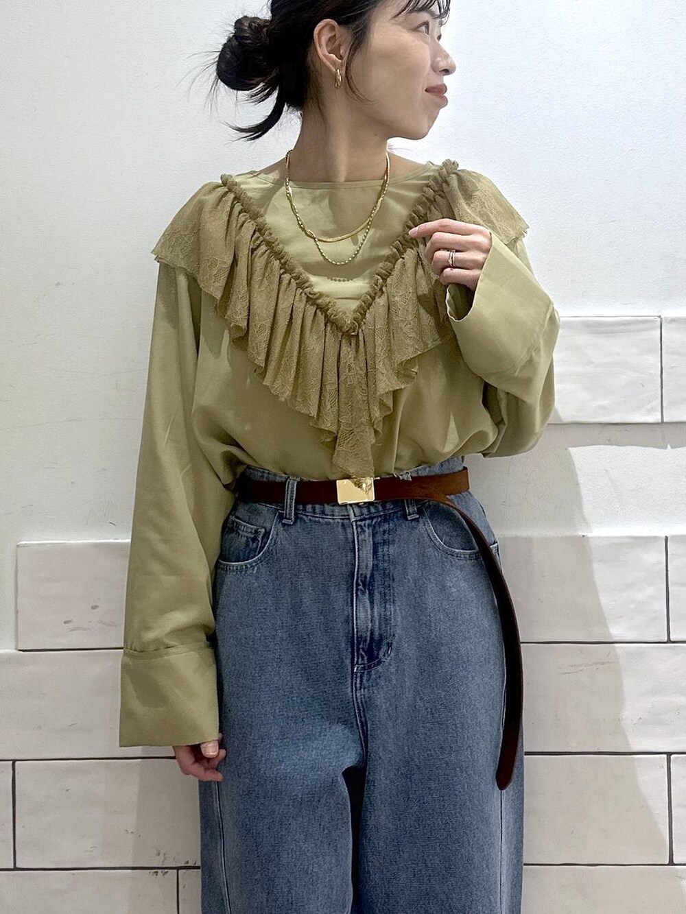 ブルー系のデニムパンツ、ブラウン系のベルトを着用したレディースの冬コーディネートの3枚目の写真