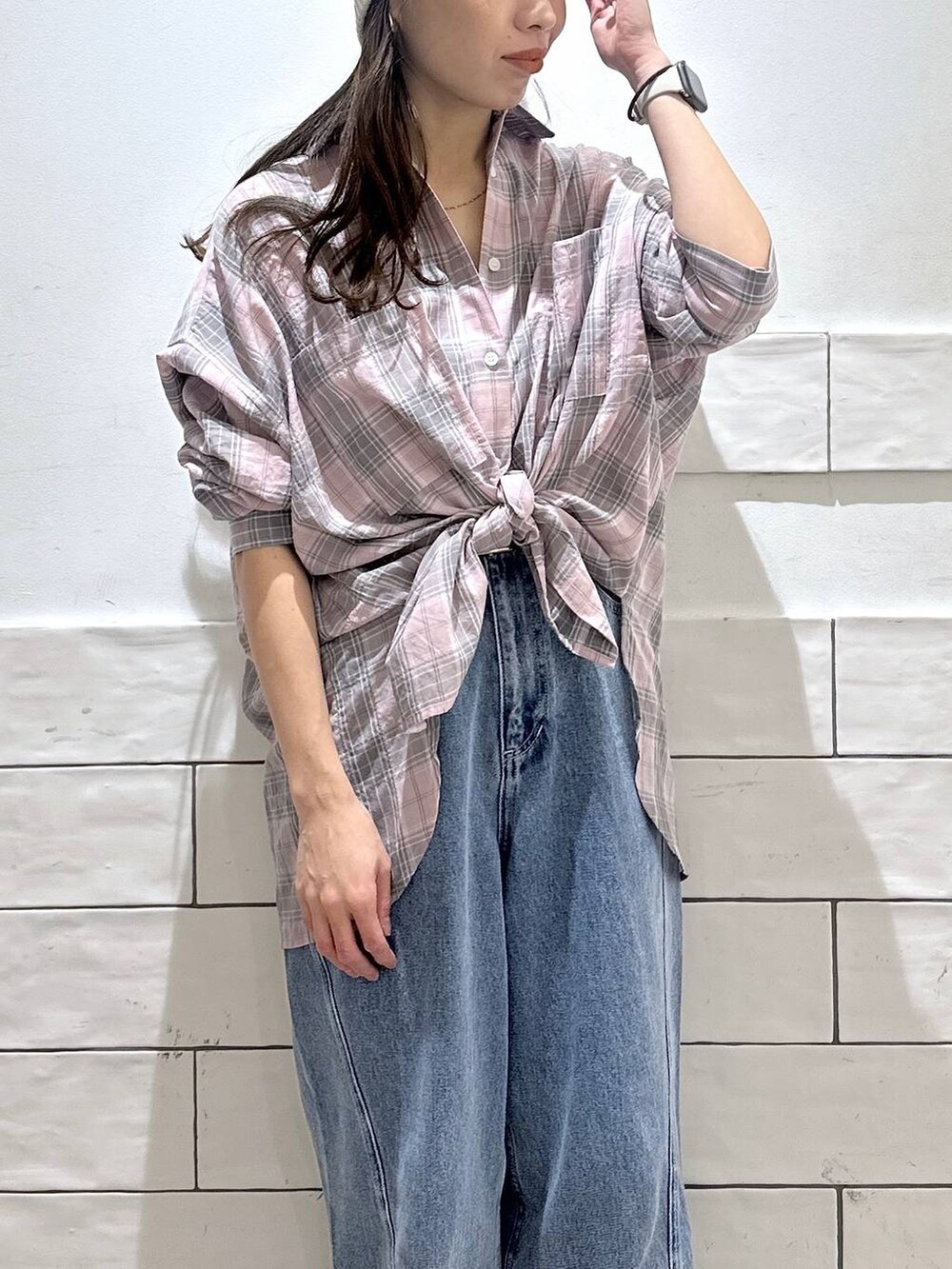 ブルー系のデニムパンツ、ピンク系のシャツ/ブラウス、ホワイト系のニットキャップ/ビーニーを着用したレディースの春コーディネートの2枚目の写真