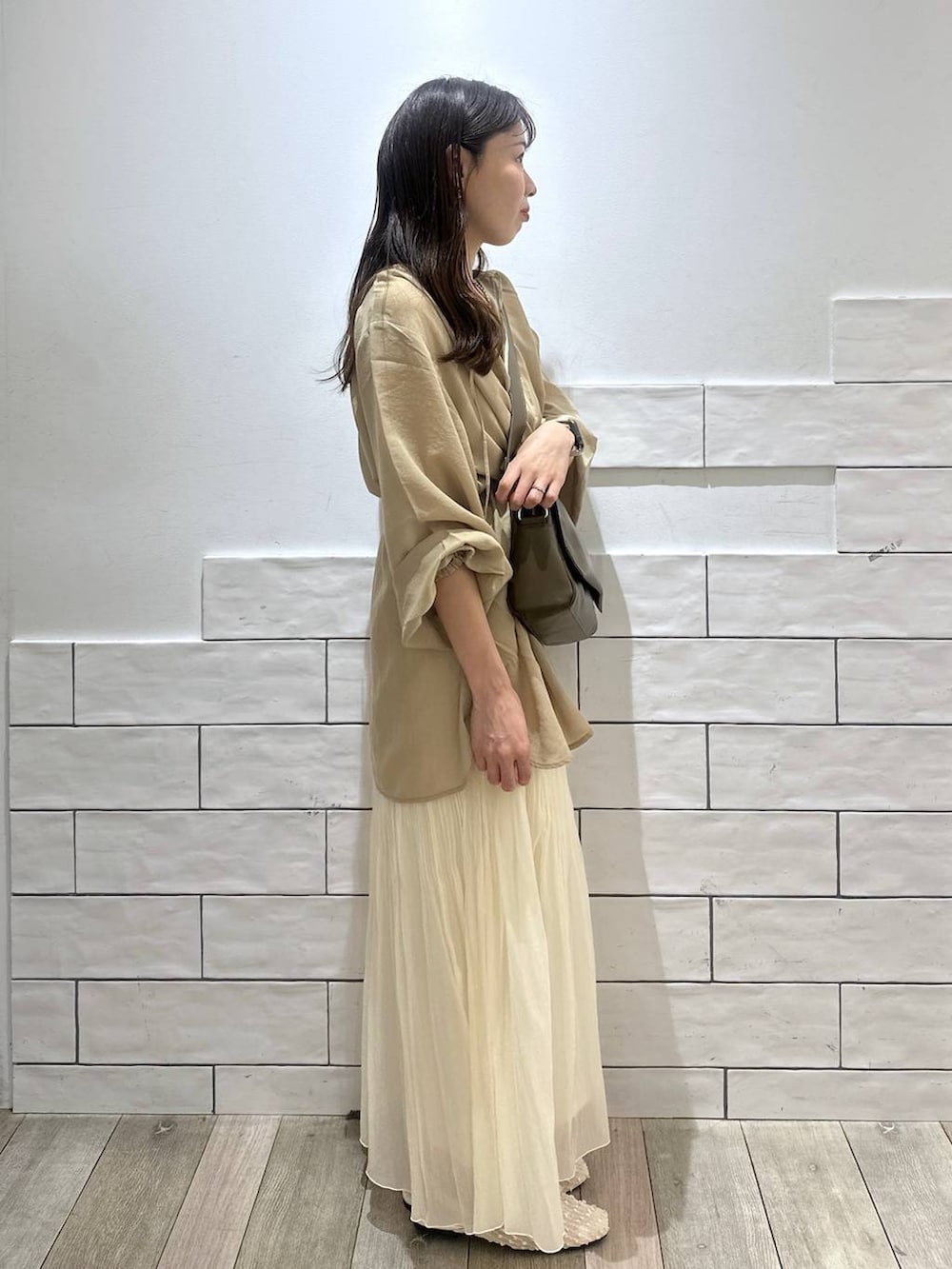 ブラウン系のショルダーバッグ、ホワイト系のスカート、ブラウン系のシャツ/ブラウスを着用したレディースの春コーディネートの2枚目の写真